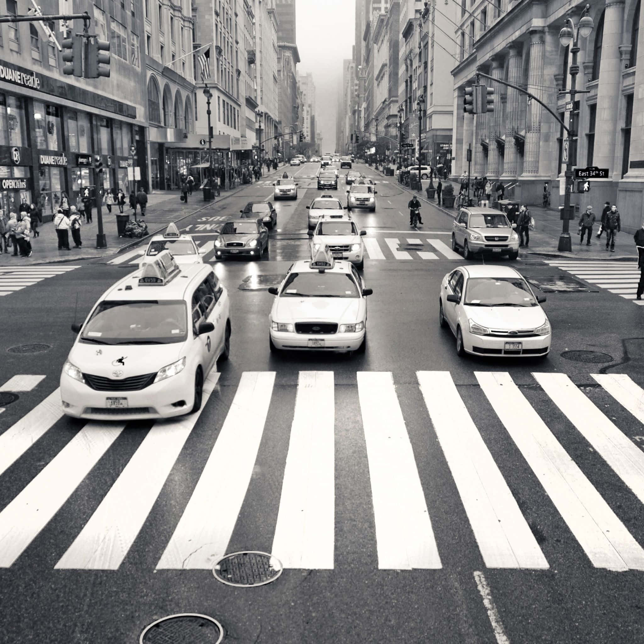Black And White Street 桌布 壁紙 — 黑白照片，繁忙的城市街道上，的士和行人在陰天穿越濕漉漉的行人過路處。