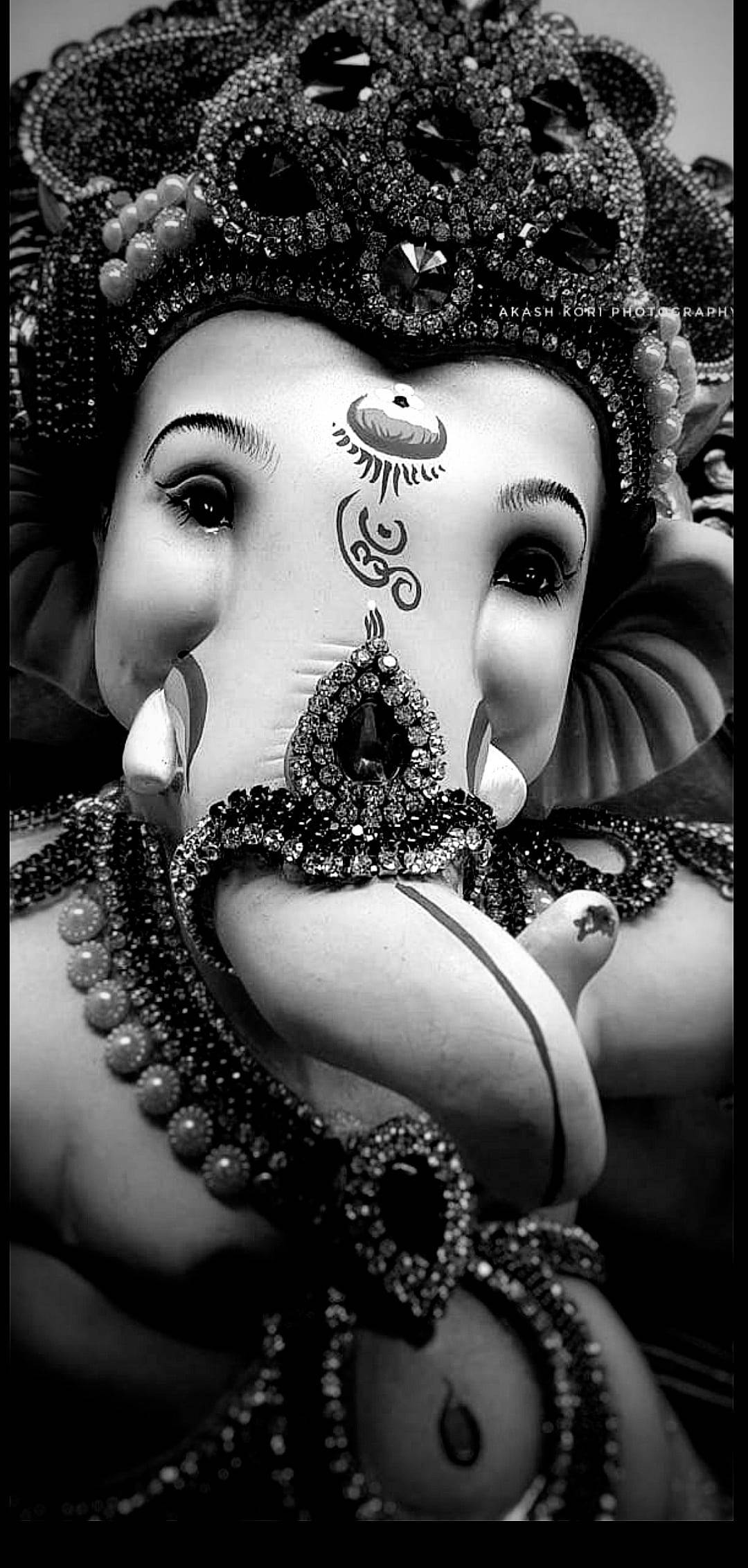 ganesh iPhone 桌布 壁紙 — 黑白特寫，華麗的象頭神雕像飾有複雜珠寶和細緻面部標記。