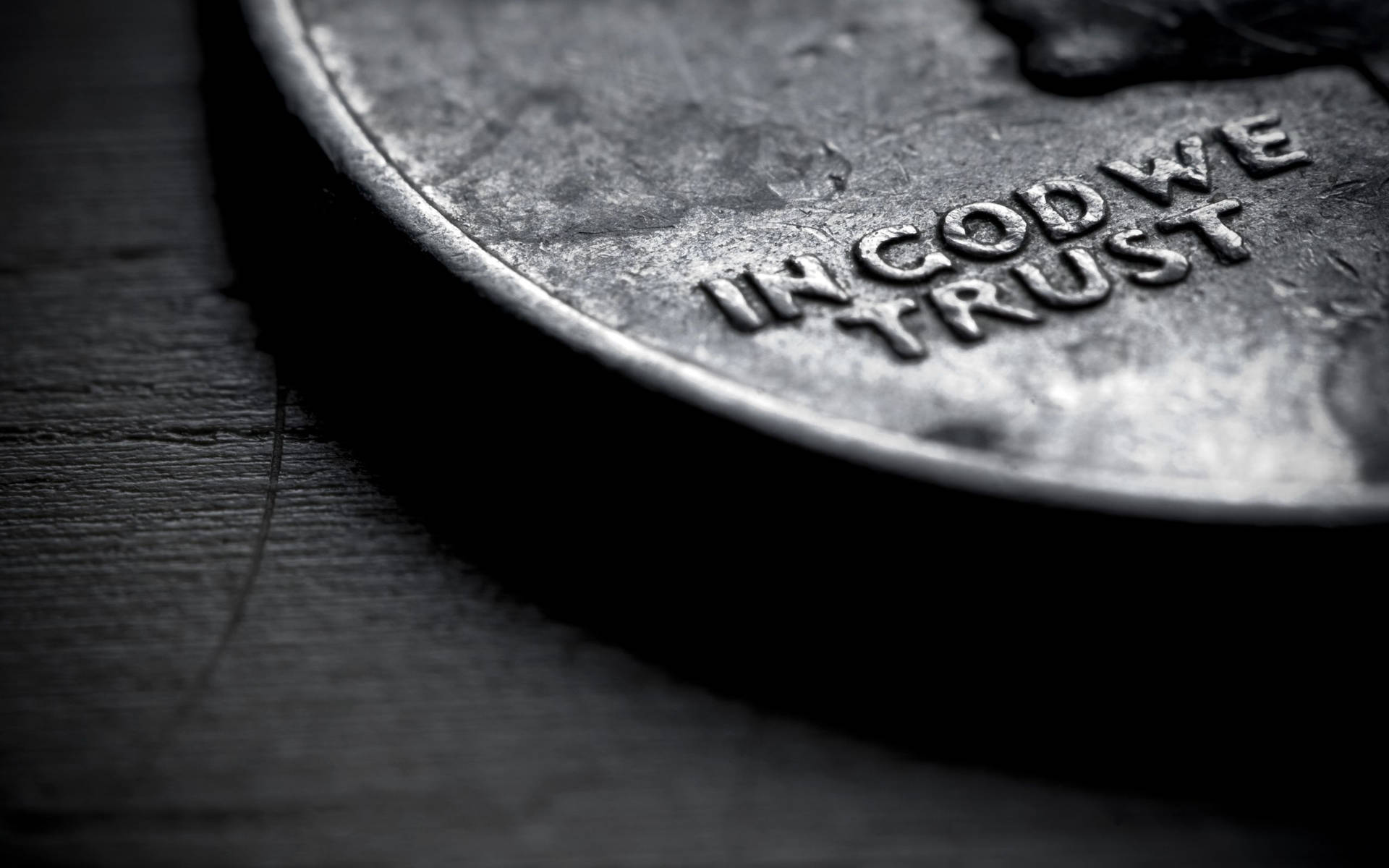 一枚磨損嘅美國一分錢硬幣特寫，上面有「IN GOD WE TRUST」，放喺深色木頭上。
