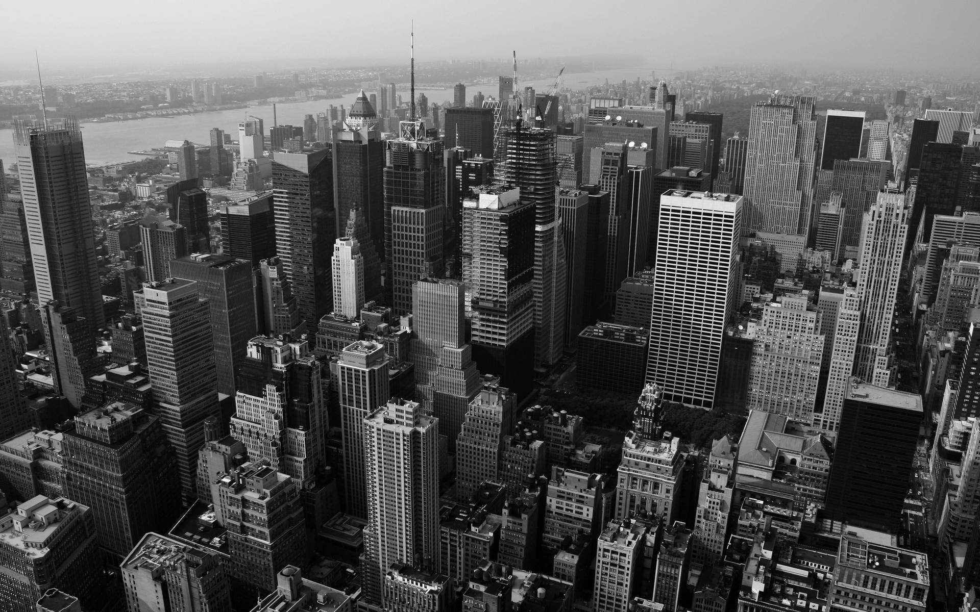黑白航拍視圖，密集的城市天際線，高樓大廈和河流。