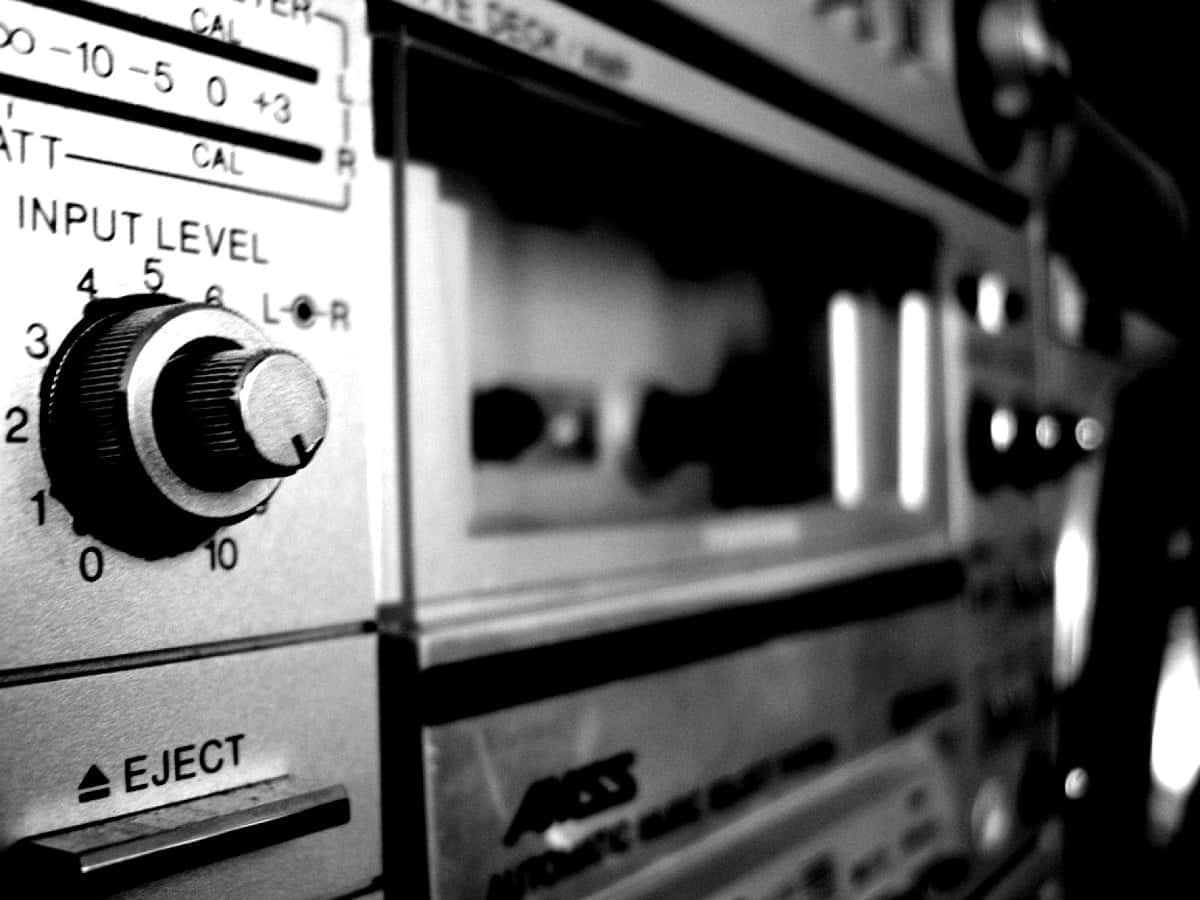 黑白經典收音機接收器 壁紙 — 復古卡式錄音座輸入電平旋鈕和彈出按鈕的特寫黑白照片，景深較淺。