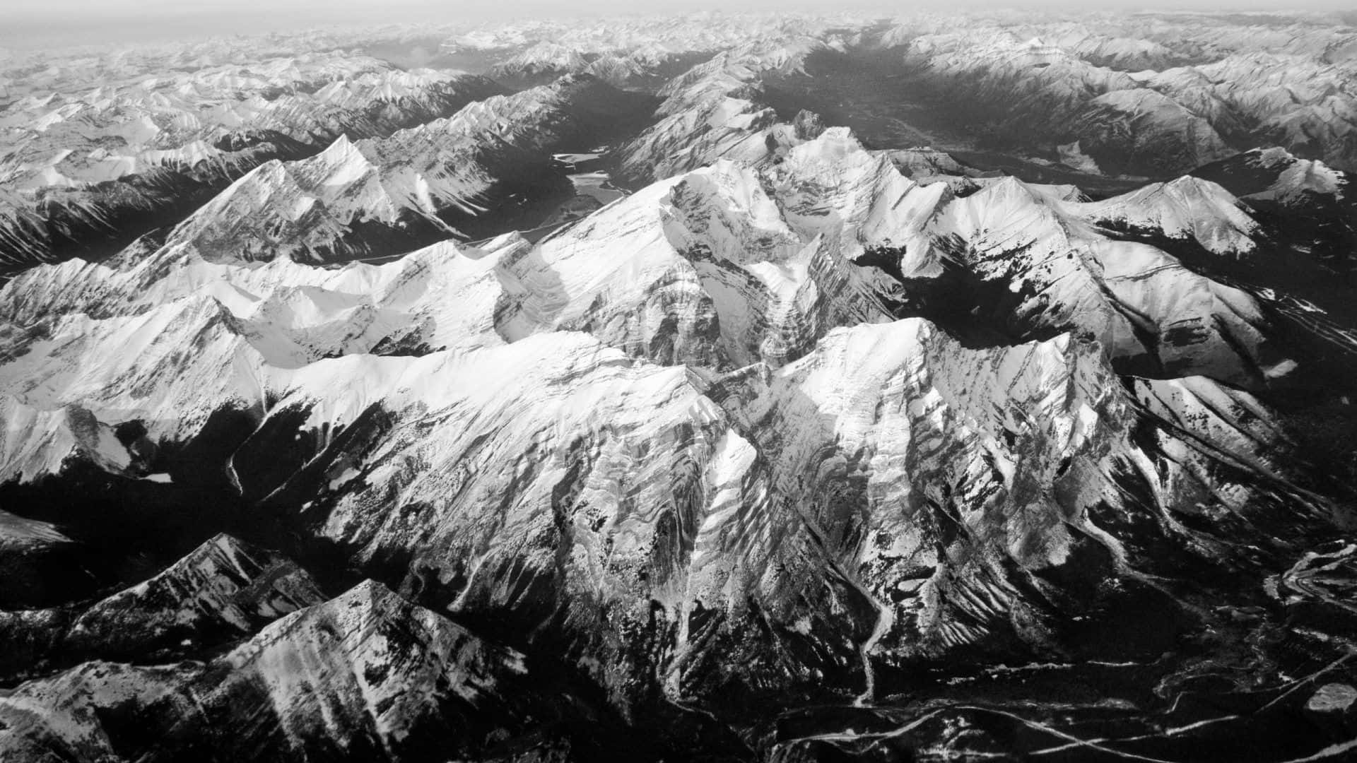 Black And White Nature 桌布 壁紙 — 黑白航拍視角，無盡的雪山山脈延伸至地平線。