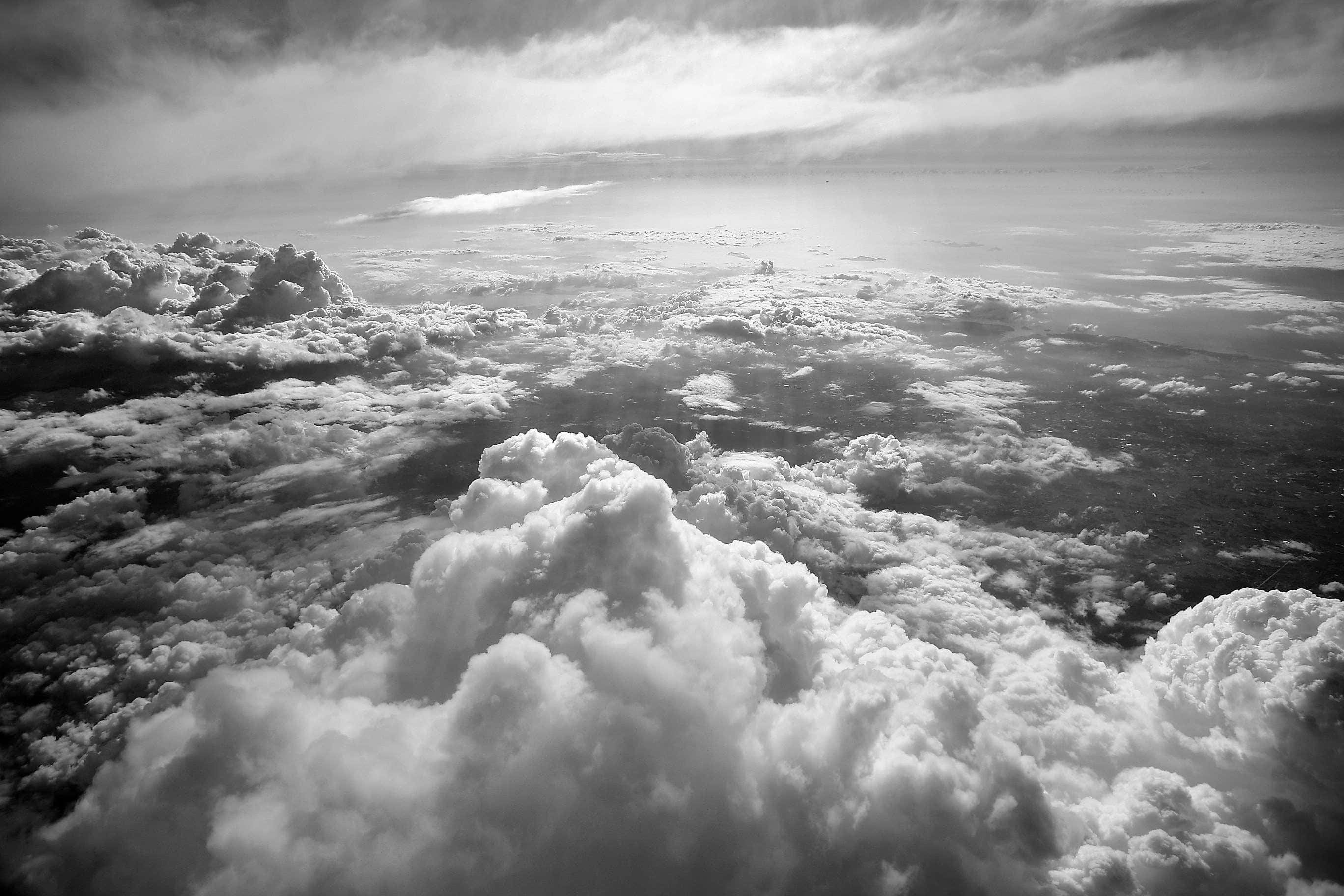 Black And White Sky 桌布 壁紙 — 黑白航拍視角，翱翔於有紋理的雲層之上，柔和光線穿過天空。