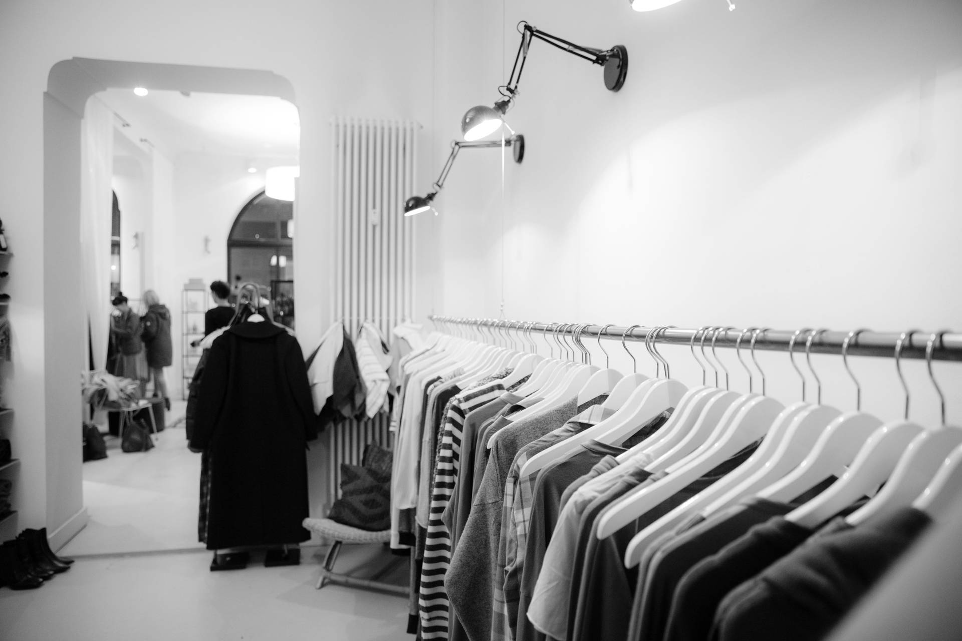 極簡服裝店，有衣架和瀏覽的人。