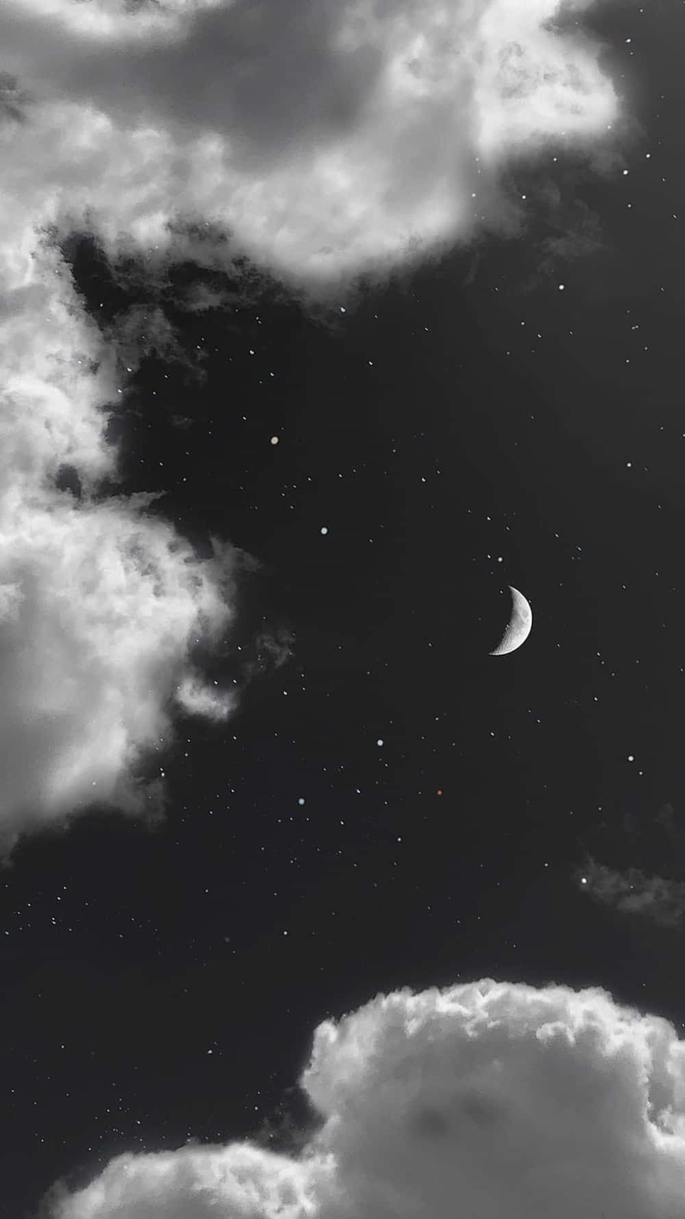新月和星星在黑暗的夜空中透過雲層窺視。