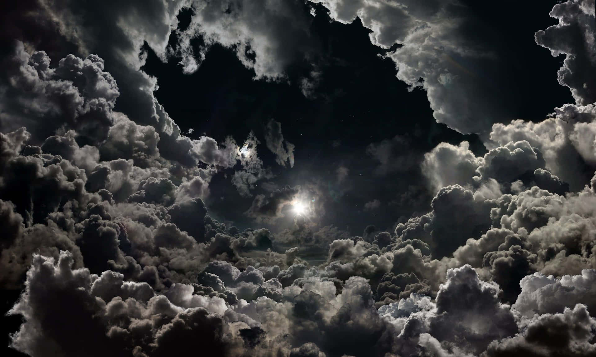 月光在黑暗的夜空中穿透厚厚的暴風雲層。