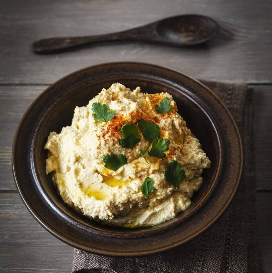 黑碗盛裝的鵝肝醬配黑湯匙 壁紙 —  creamy hummus 配上新鮮歐芹和紅椒粉，放在木桌上的古樸棕色碗中。