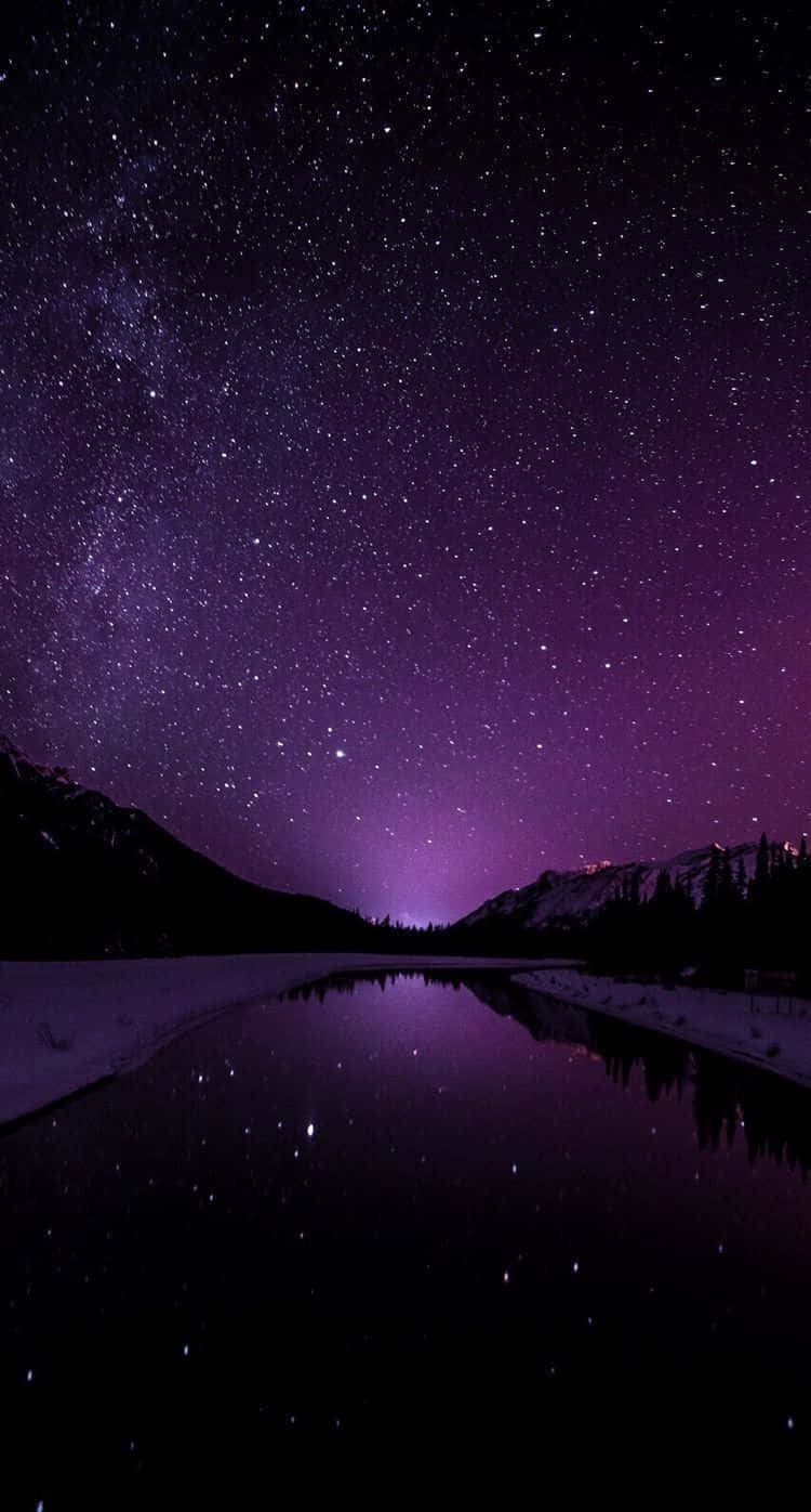 繁星點點的紫色夜空倒映在平靜的湖面上，四周環繞著積雪的山巒。