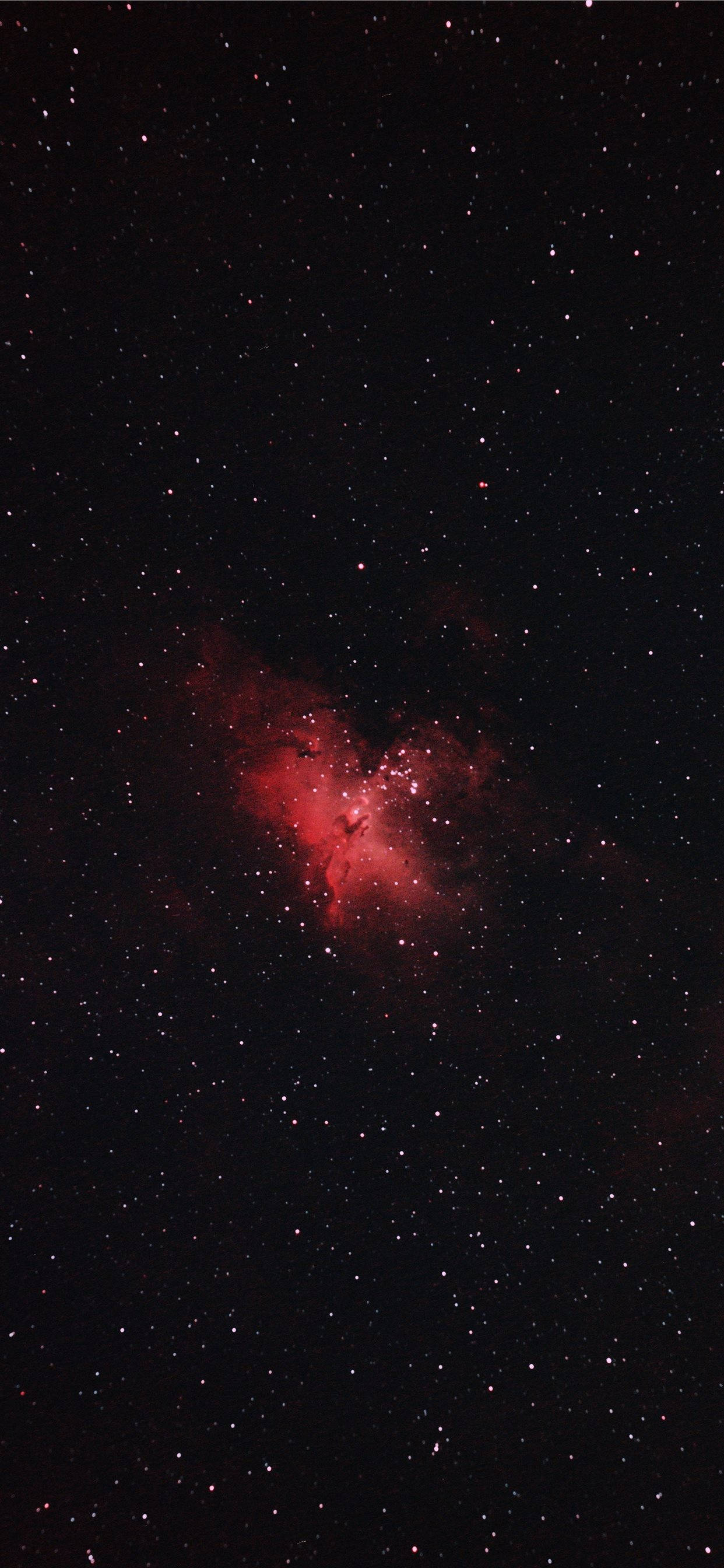 黑紅色星系 壁紙 — 在深邃的黑色宇宙中，一片充滿活力的紅色星雲在密集的星場中發光。