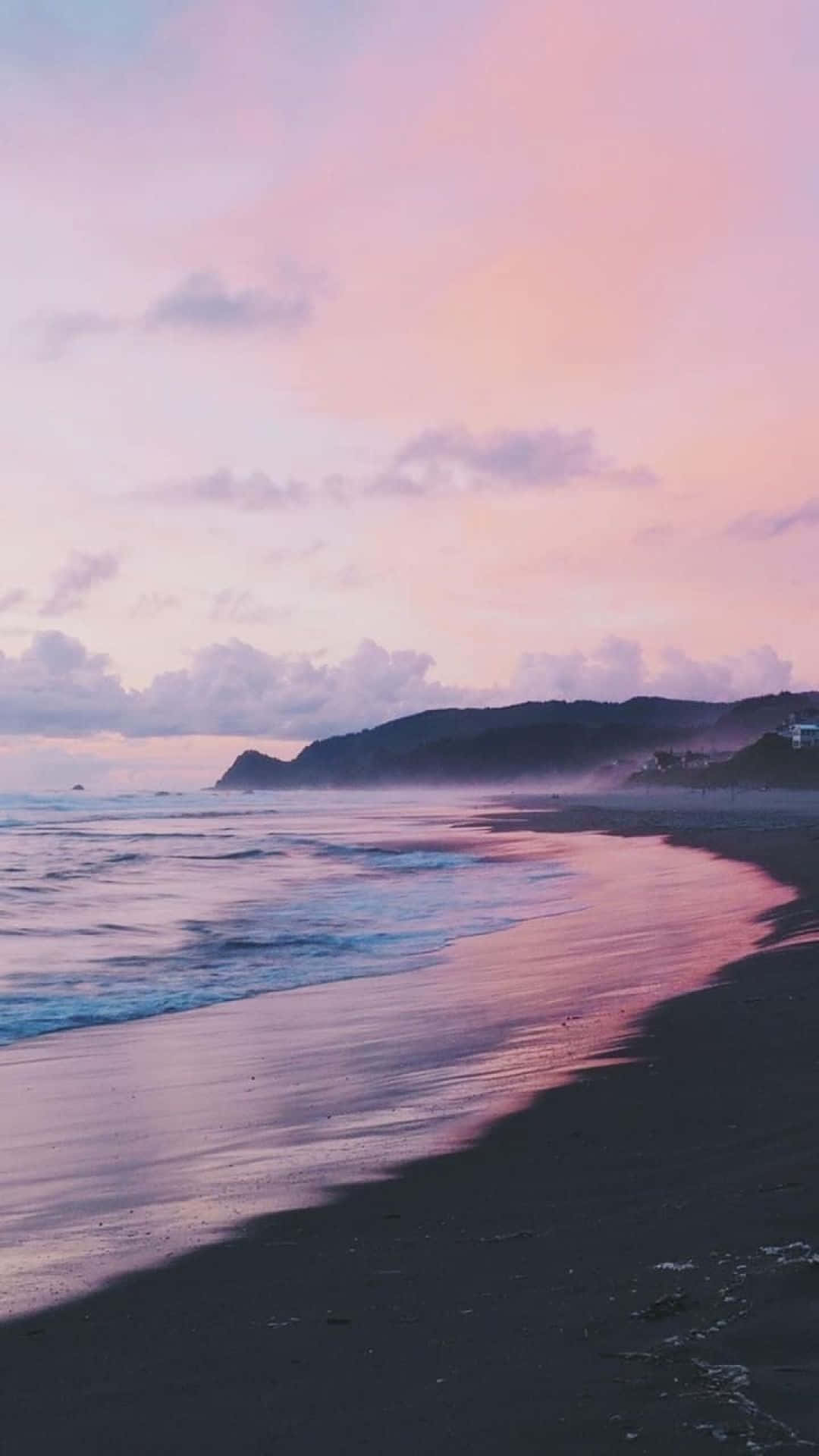 黑紫海灘美學圖片 壁紙 — 黃昏時分的寧靜海灘，粉紅色和紫色的天空倒映在濕沙和輕柔的海浪上。