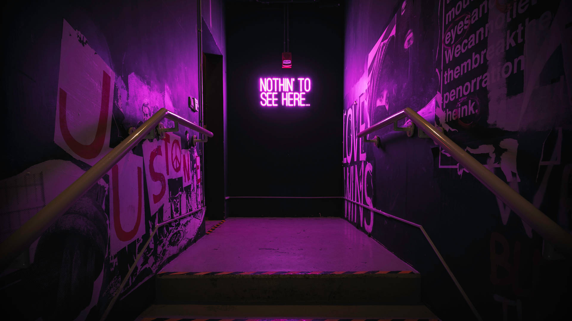 在佈滿塗鴉的樓梯間，紫色霓虹標誌寫著「NOTHIN TO SEE HERE」。