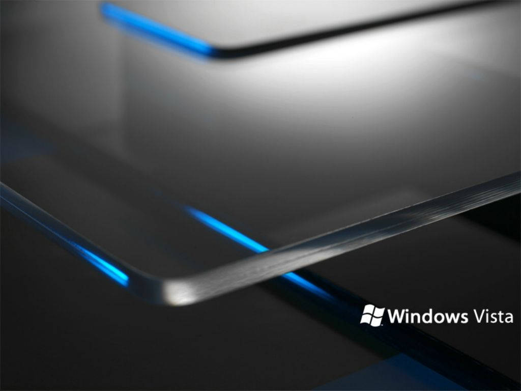 黑與藍 Windows Vista 壁紙 — 閃亮的金屬表面，帶有發光的藍色邊緣和柔和的光線反射，在深色背景上。
