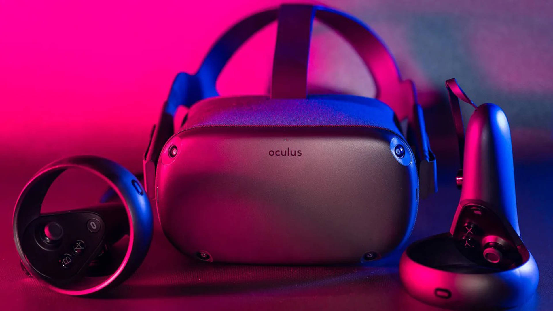 黑色 Oculus Quest 2 設備 壁紙 — 一個時尚的Oculus VR頭戴式裝置和控制器，在黑暗的表面上沐浴在充滿活力的粉紅色和藍色霓虹燈中。