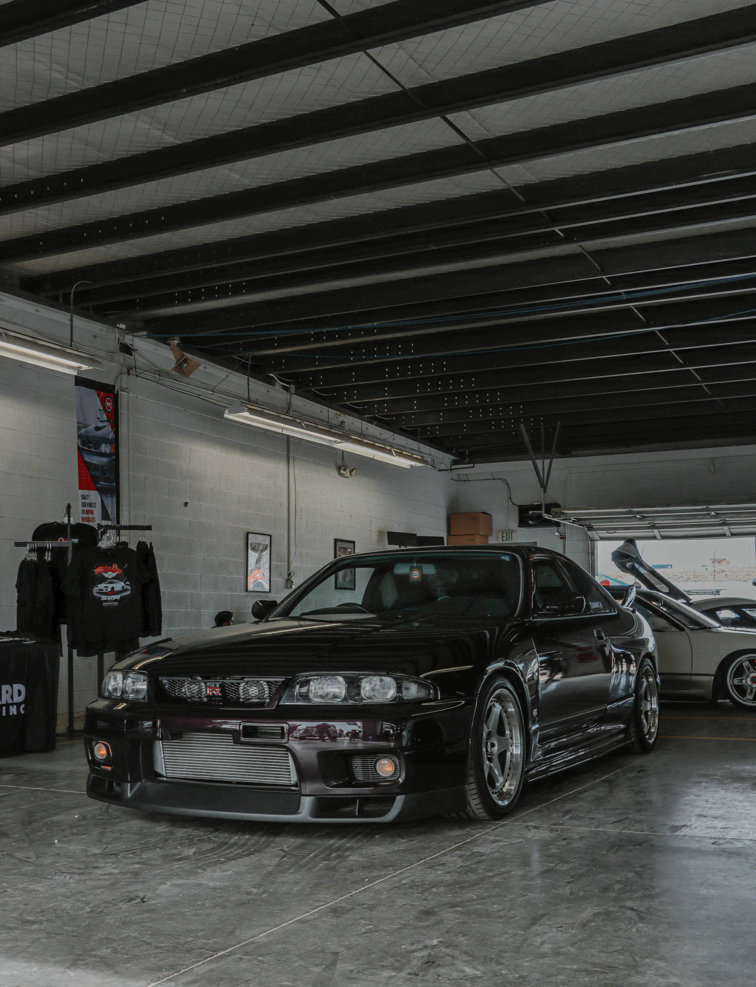 黑色日產Skyline GT-R在有外露橫樑的混凝土車庫中。