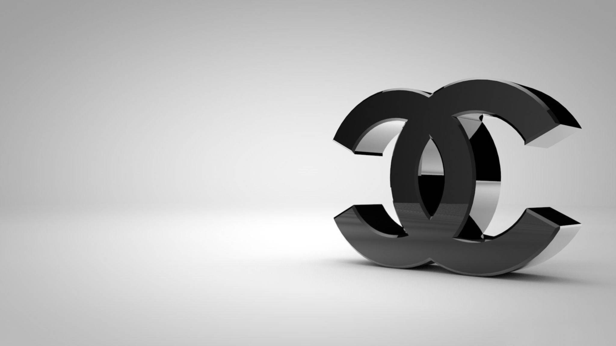 黑色3D香奈兒標誌 壁紙 — 一個時尚的黑色 Chanel 標誌在極簡灰色漸變背景上突出顯示。