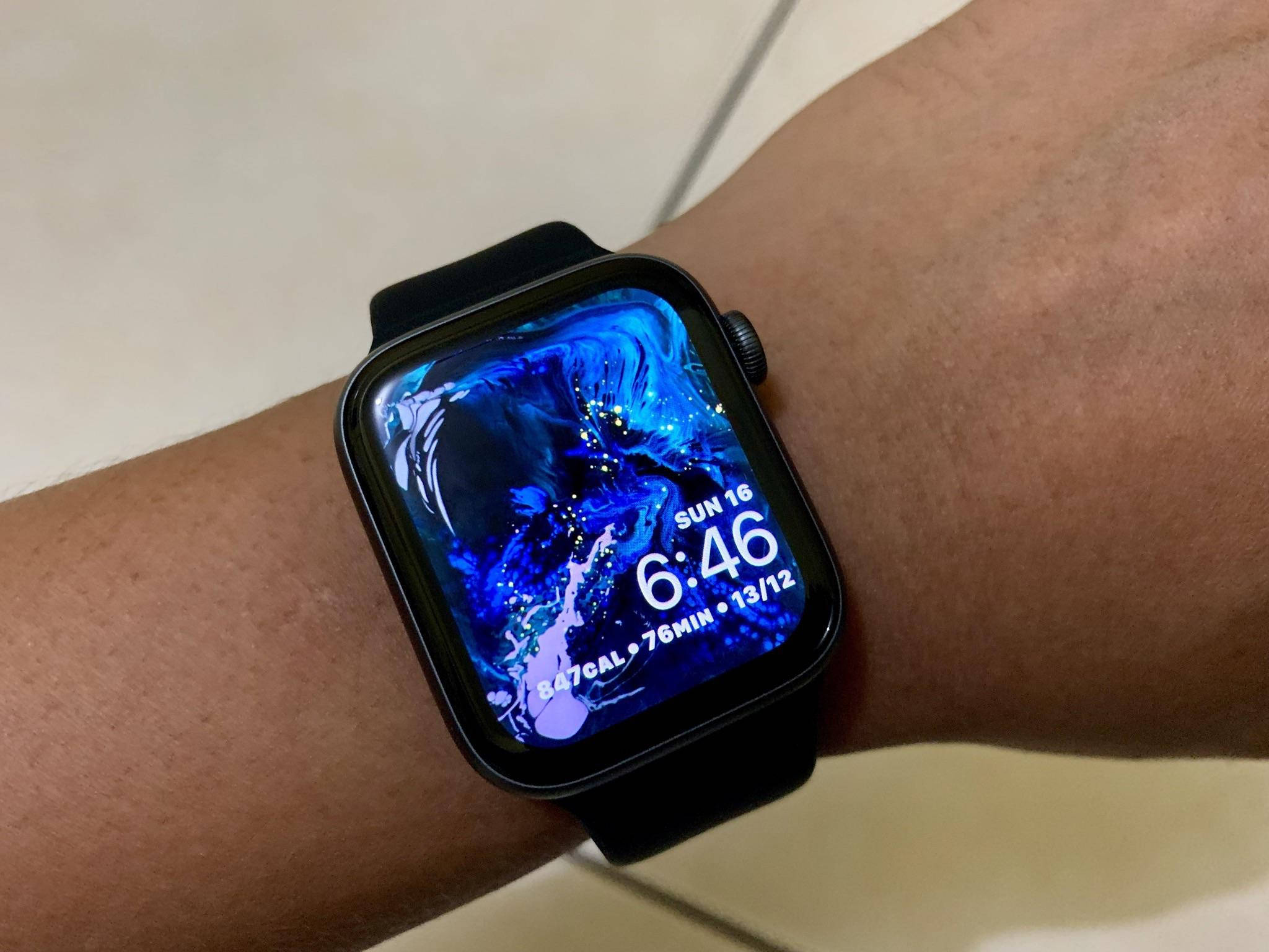 黑色Apple Watch 壁紙 — 一隻智能手錶帶有鮮豔的藍色抽象背景，在人的手腕上顯示時間和健身統計數據。