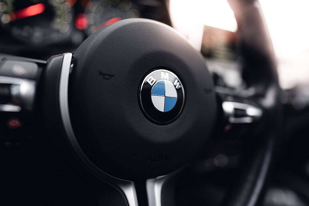 黑色BMW汽車方向盤 壁紙 — 黑色BMW軚盤特寫，標誌置中，柔和環境光線下拍攝。