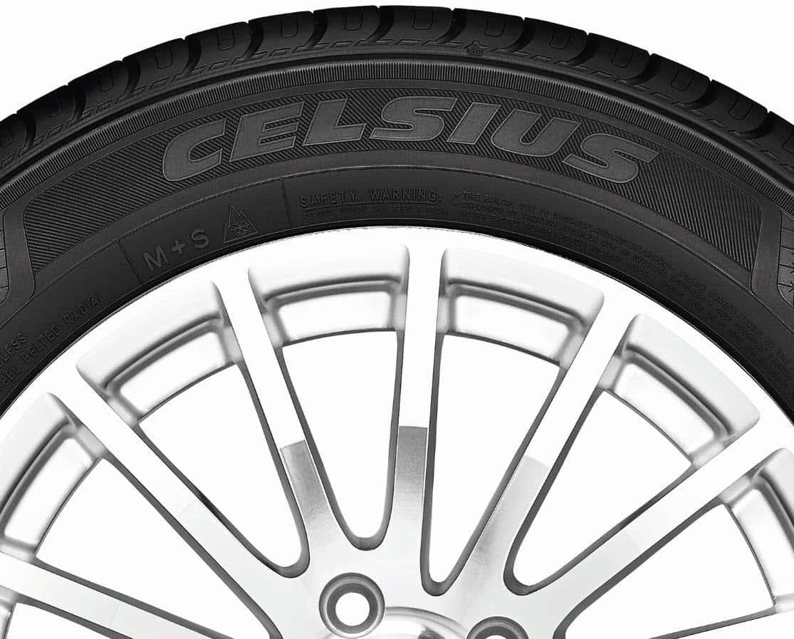 Winter Tires 桌布 壁紙 — 黑色Celsius輪胎安裝在銀色多輻合金輪圈上的特寫，背景為白色。