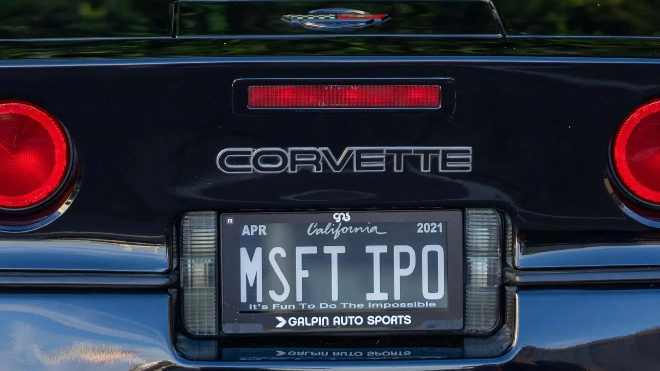 Car License Plate 桌布 壁紙 — 黑色Corvette車尾特寫，配有紅色尾燈和寫有MSFT IPO的加州車牌。