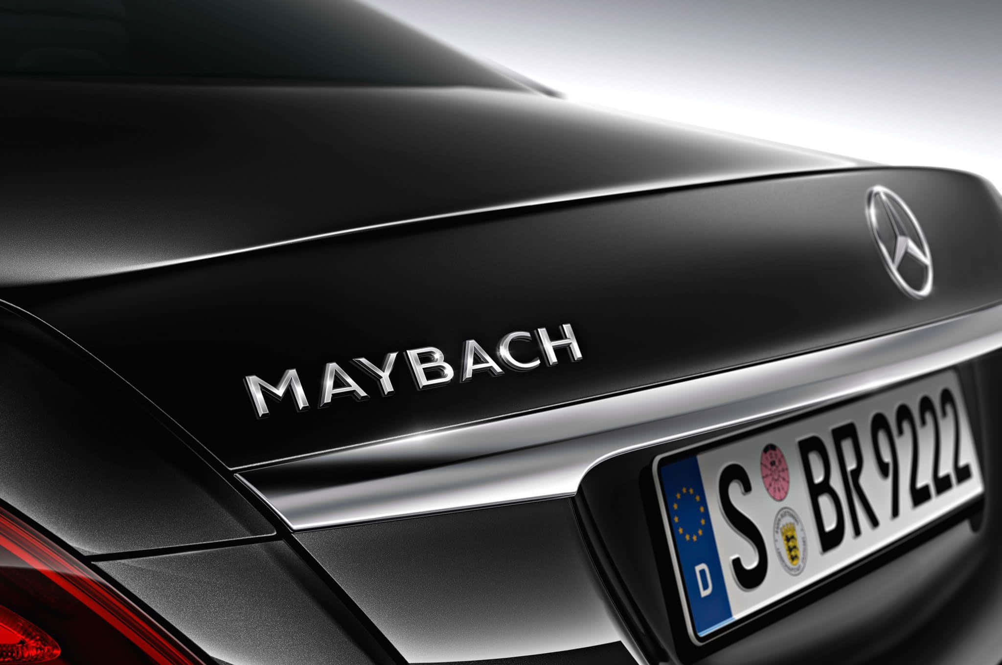 Maybach 桌布 壁紙 — 黑色Maybach汽車後車廂近距離特寫，帶有鍍鉻徽章和德國車牌。