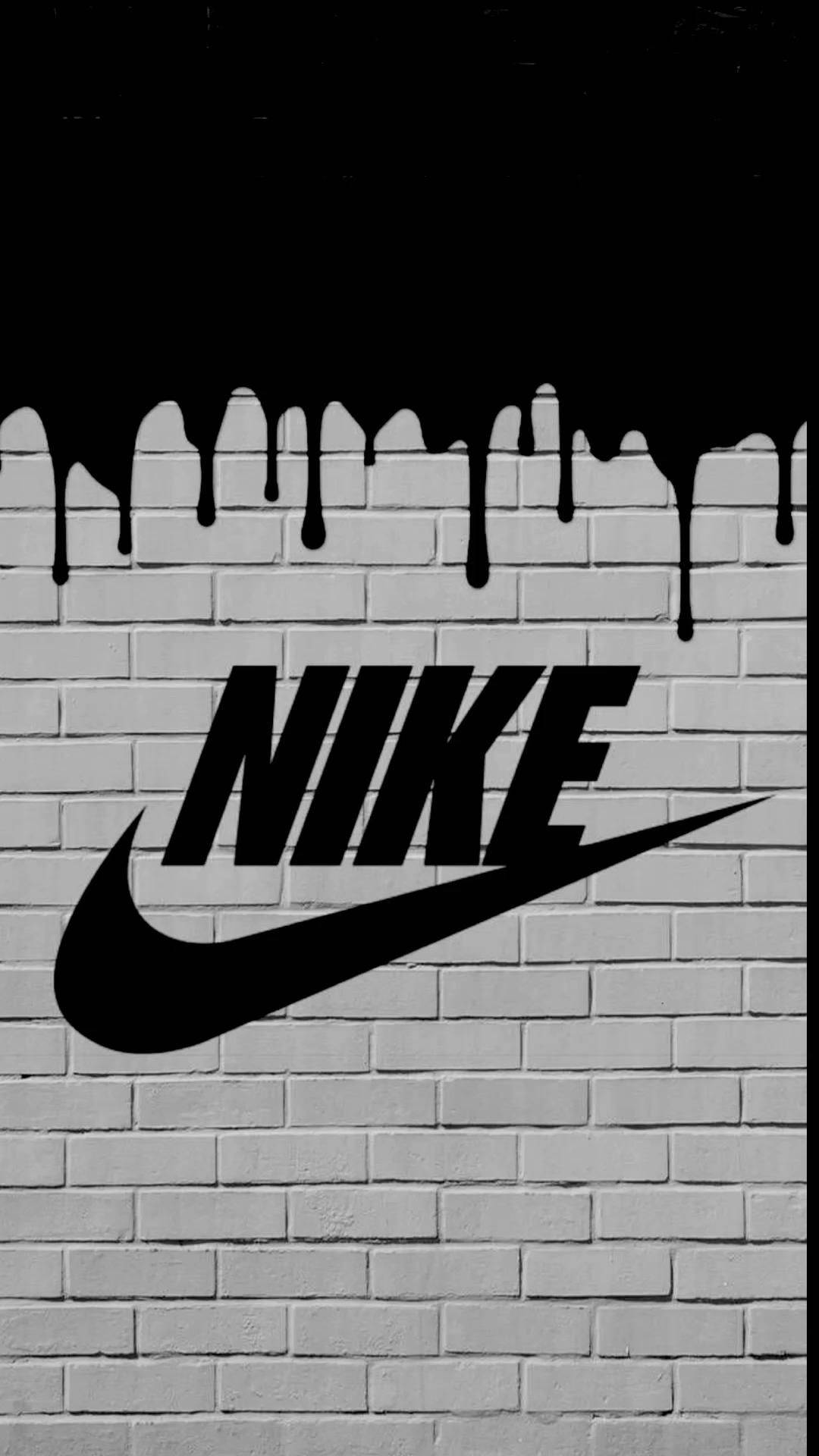 白色磚牆上滴落油漆的黑色Nike標誌。
