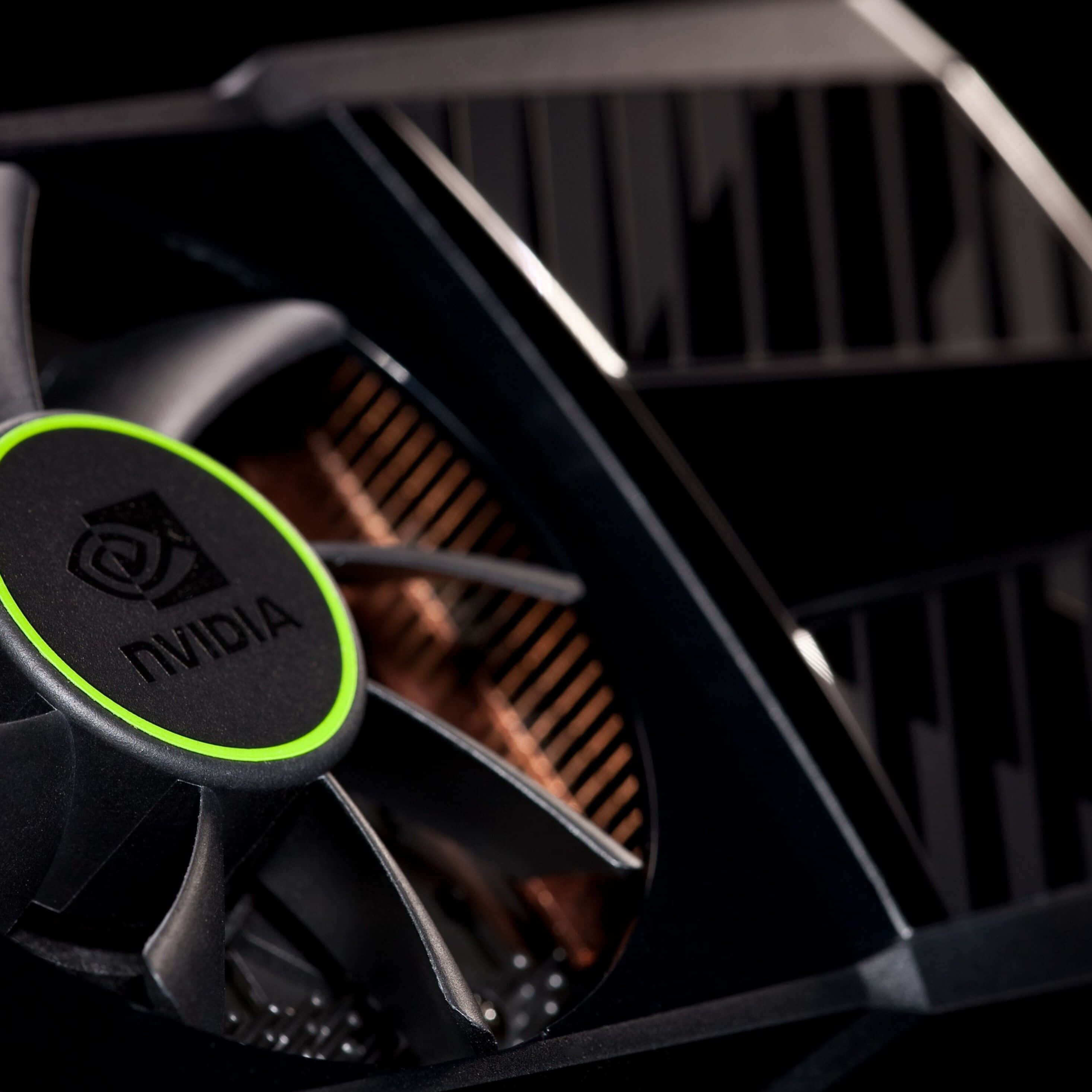4K Graphics Cards 桌布 壁紙 — 黑色NVIDIA顯示卡風扇近距離特寫，帶有綠色發光裝飾和銅質散熱片。