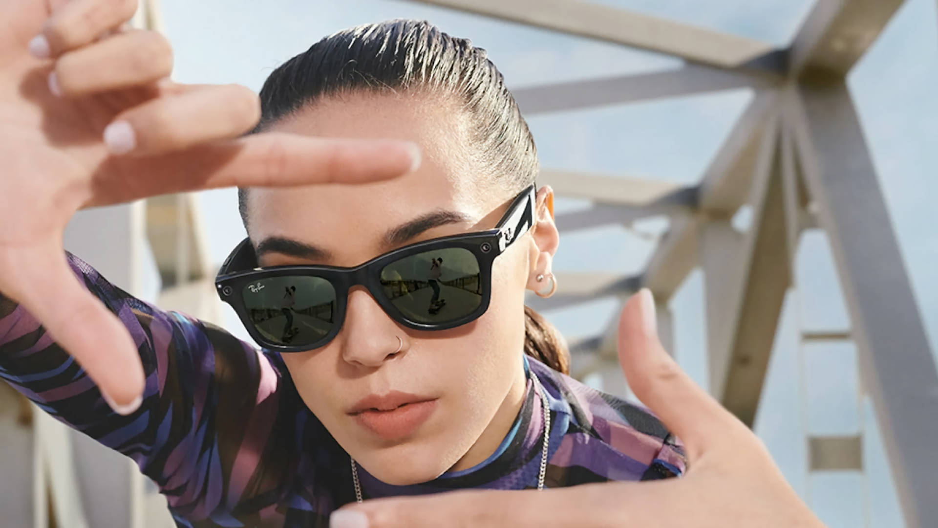 戴太陽眼鏡的女性在都市環境中以雙手框住臉龐