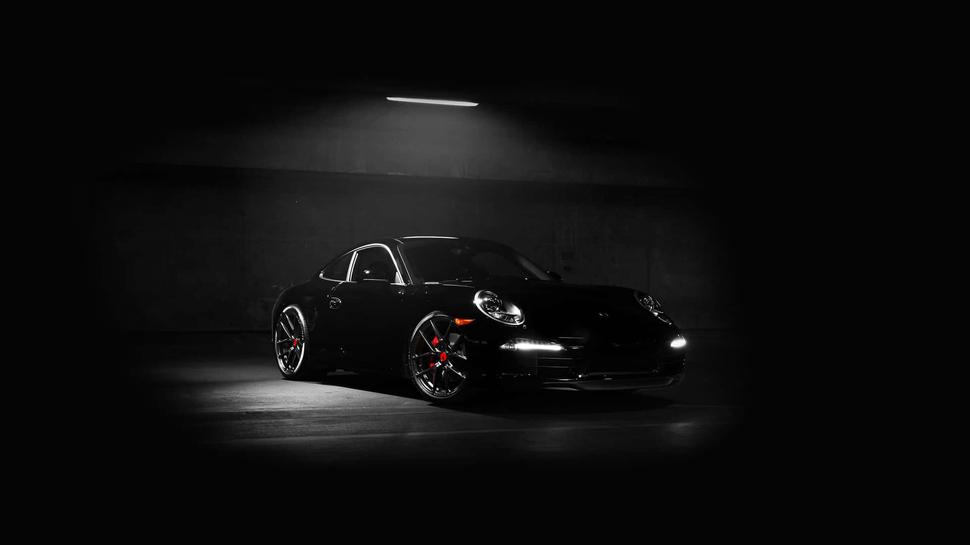 黑色保時捷911跑車在黑暗車庫中被頂燈照亮。 — 汽車 壁紙