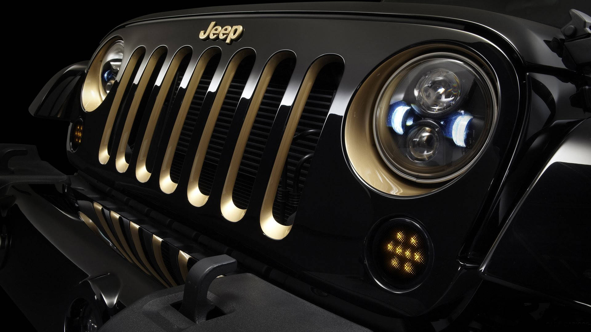 黑色Jeep，在黑暗環境中帶有金色裝飾的格柵和頭燈。
