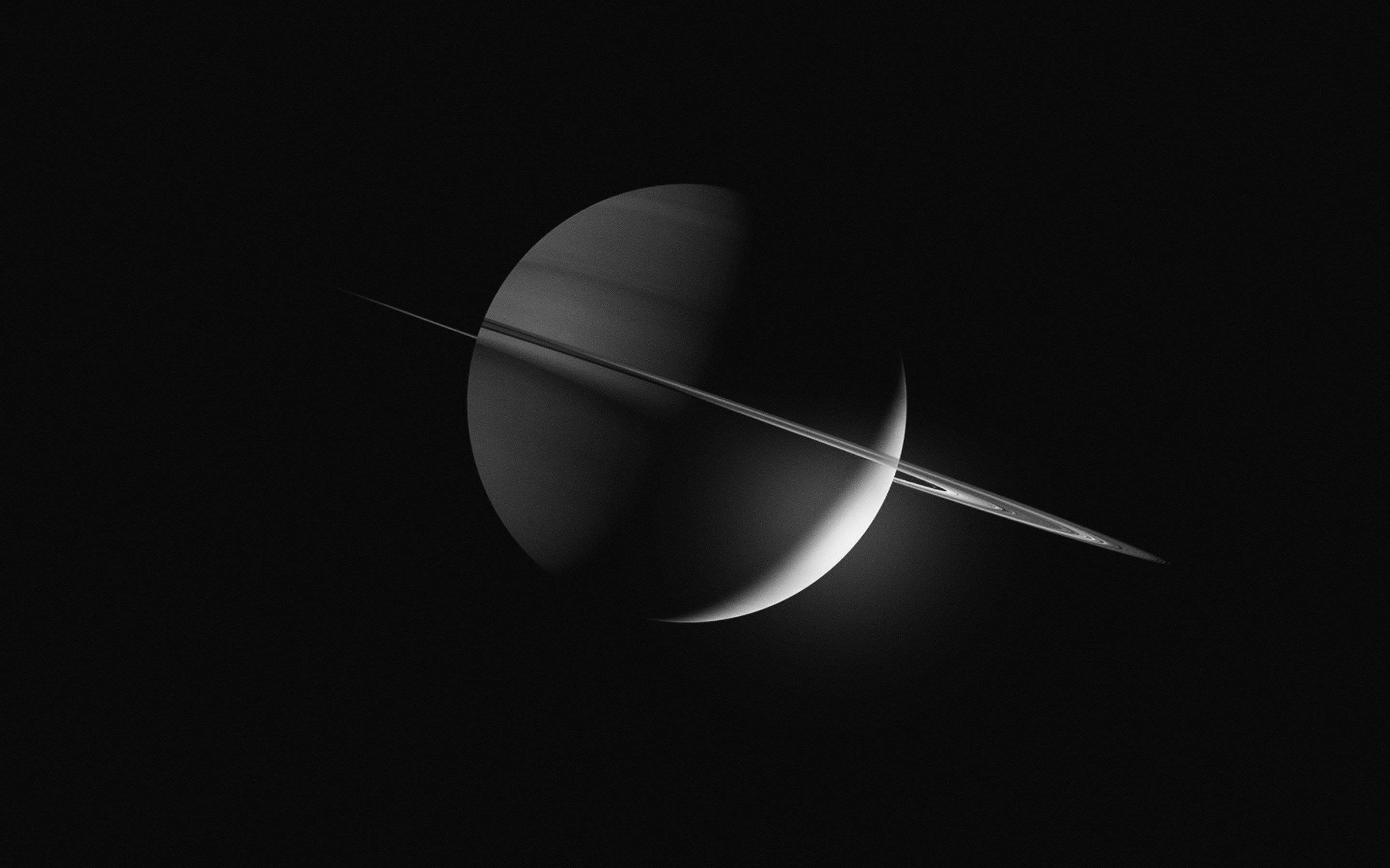 黑色土星 壁紙 — 土星的單色視圖，其標誌性環在太空虛空中投下銳利的陰影。