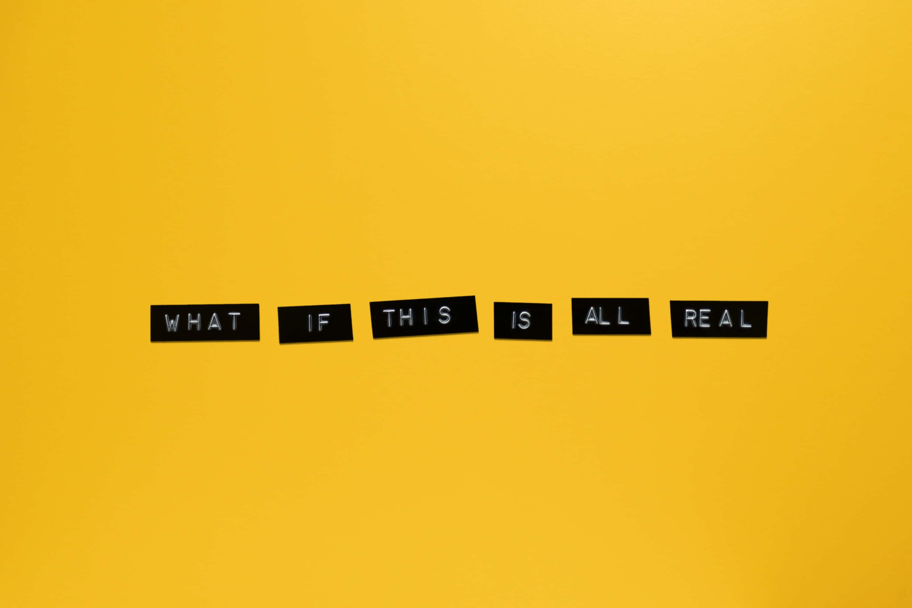 cover 桌布 壁紙 — 黑色字母瓷磚在鮮黃色背景上拼出「WHAT IF THIS IS ALL REAL」。