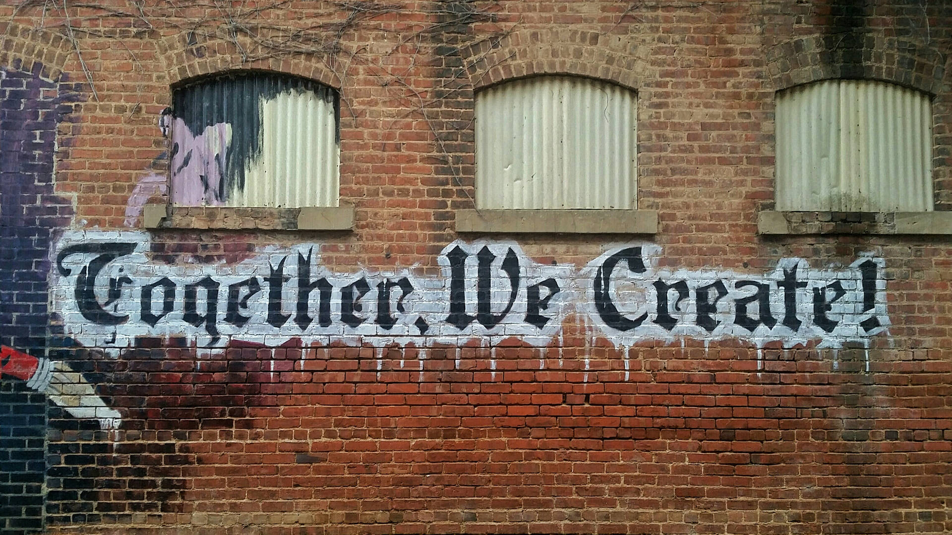 磚牆上的塗鴉壁畫，寫著 Together We Create