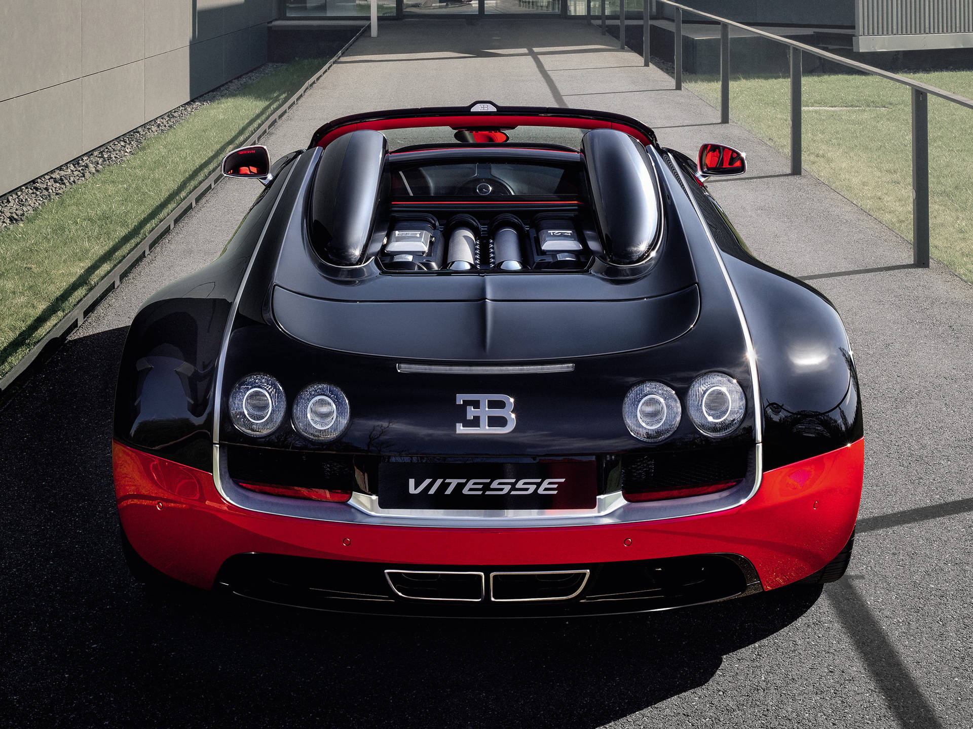 黑色和紅色的Bugatti Vitesse超級跑車，露出引擎，停在鋪砌表面上。