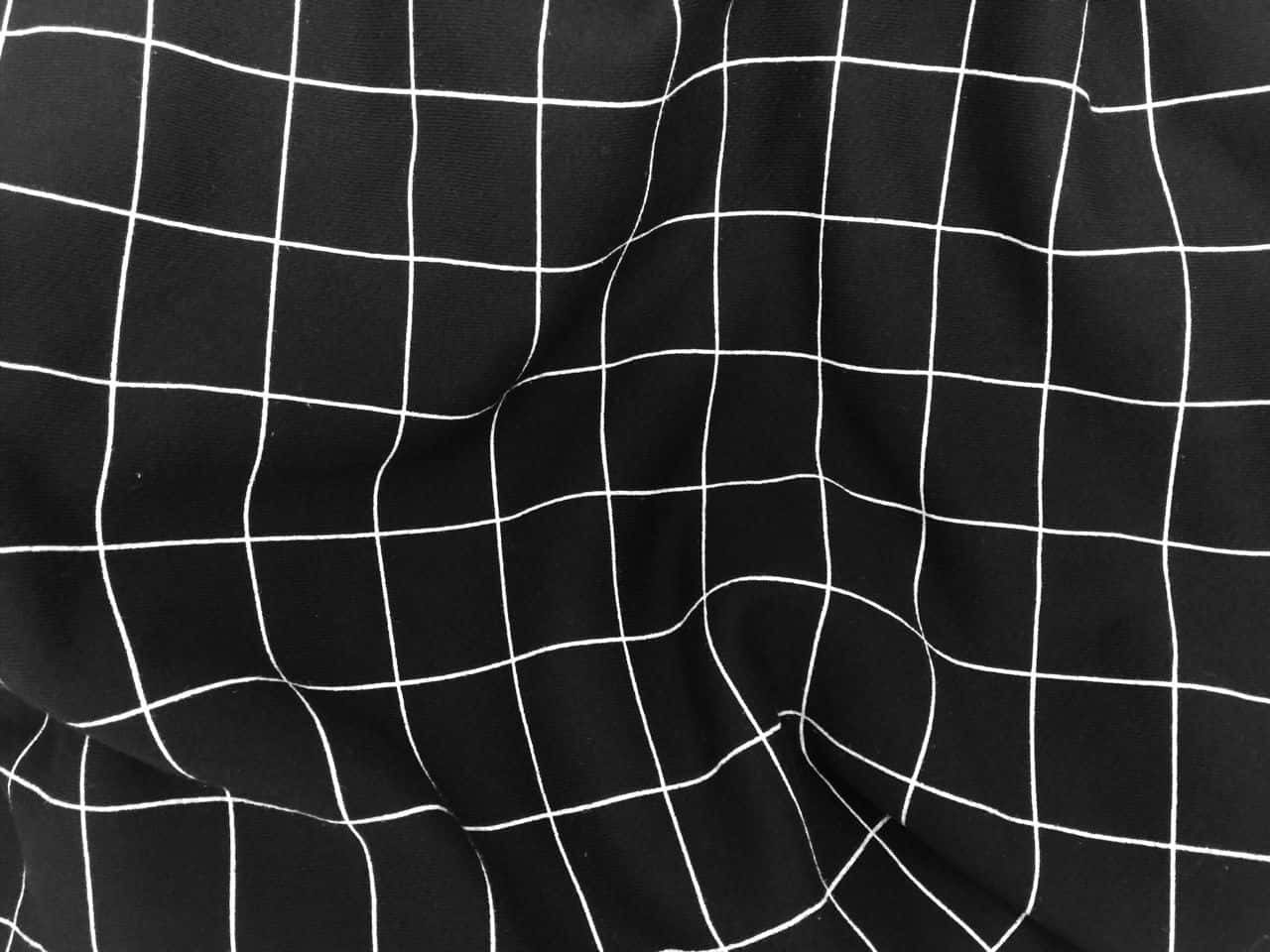 grid 桌布 壁紙 — 黑色布料帶有白色網格線，在自然光下輕柔地起伏。