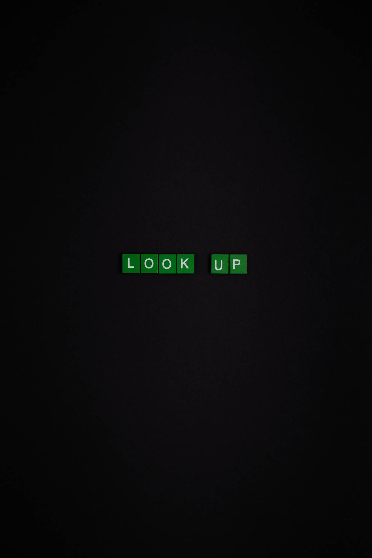 綠色拼字磚塊在黑色背景上拼出look up