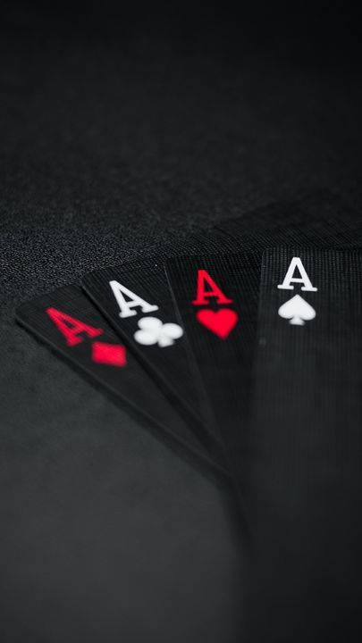 四張Ace啤牌在深色紋理表面上展開。