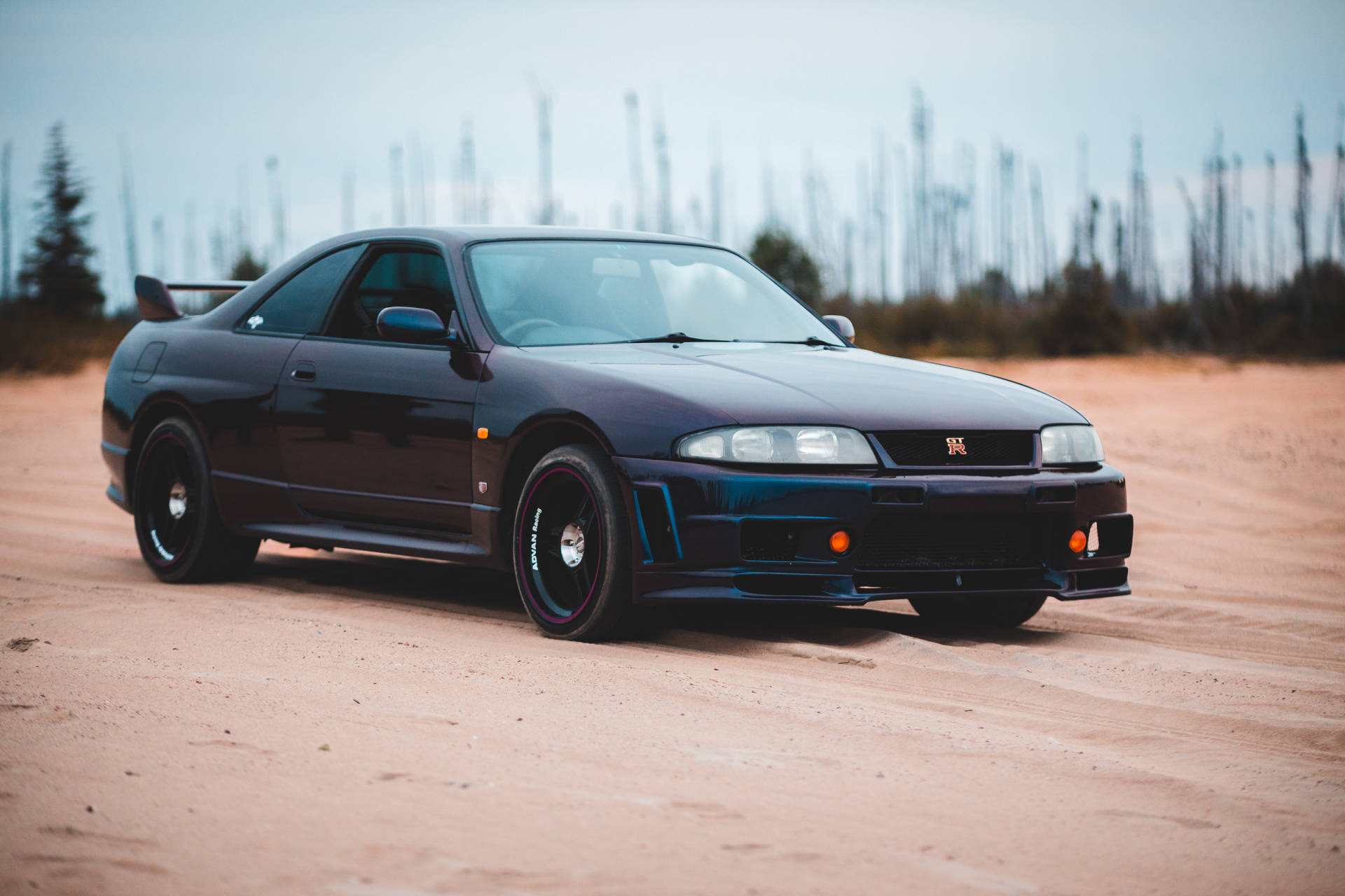 黑色日產Skyline R34在日落時停放在土路上