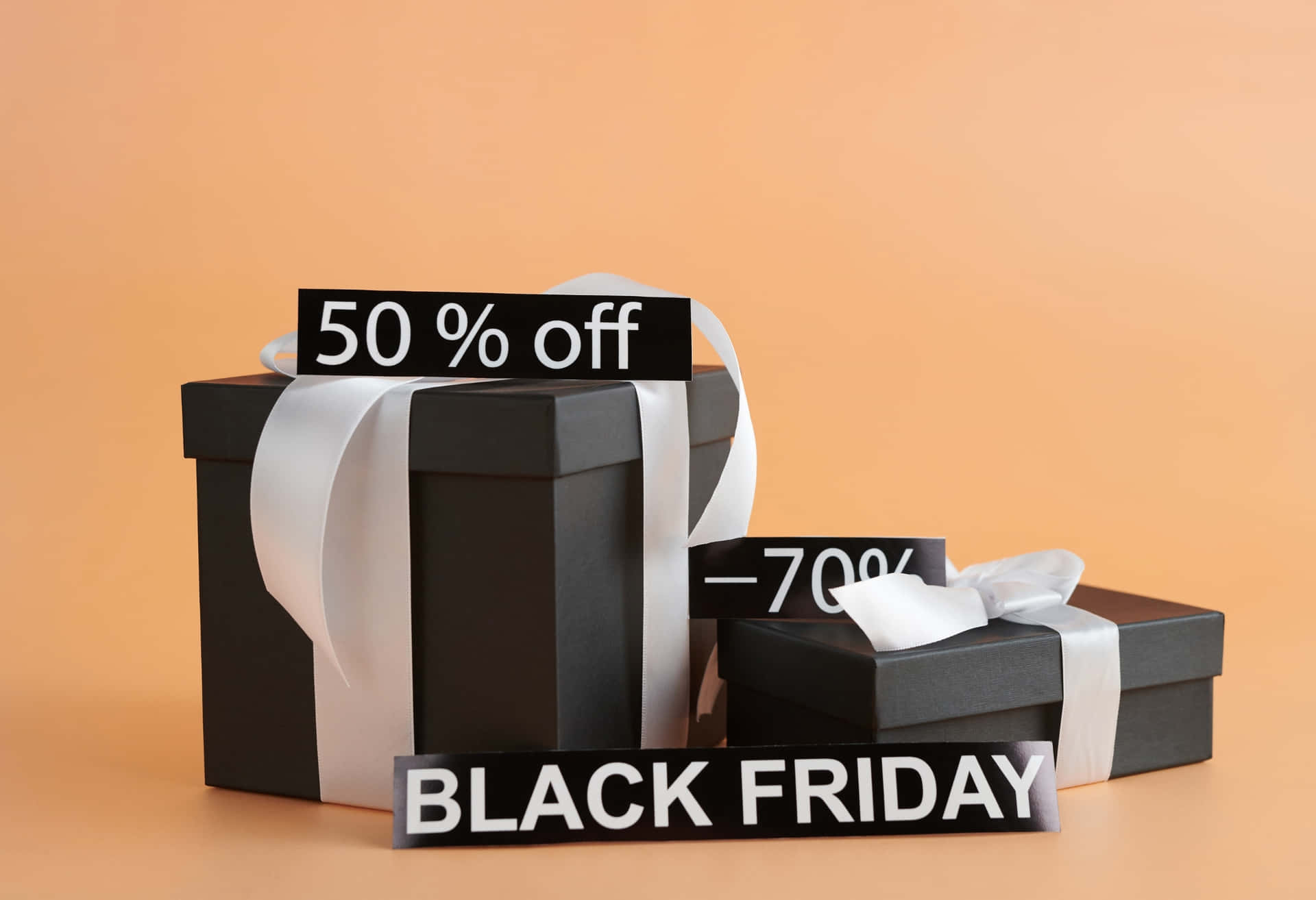 兩個黑色禮物盒，帶白色絲帶和Black Friday折扣標牌