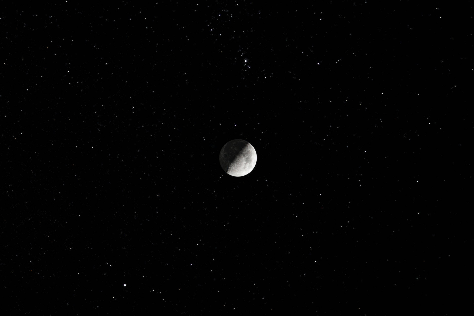 夜空中的星星環繞著處於月食狀態的彎月。