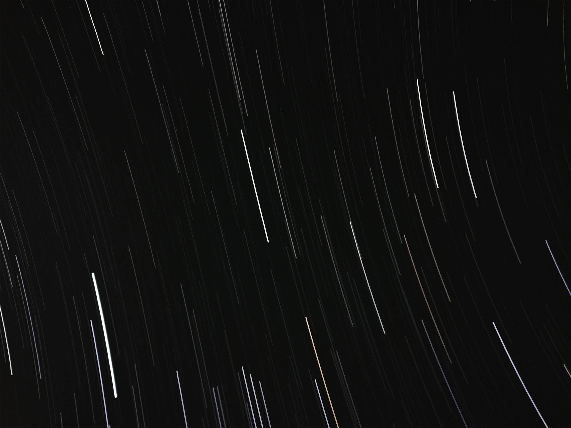 星軌在黑暗的夜空中劃出弧線的長時間曝光照片。