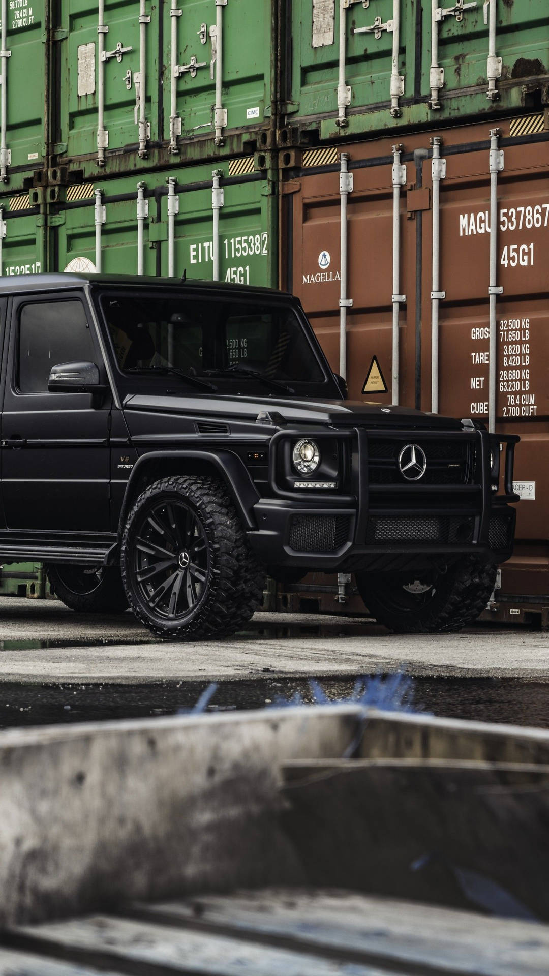 黑色梅賽德斯 G-Wagen 停在貨運集裝箱前。