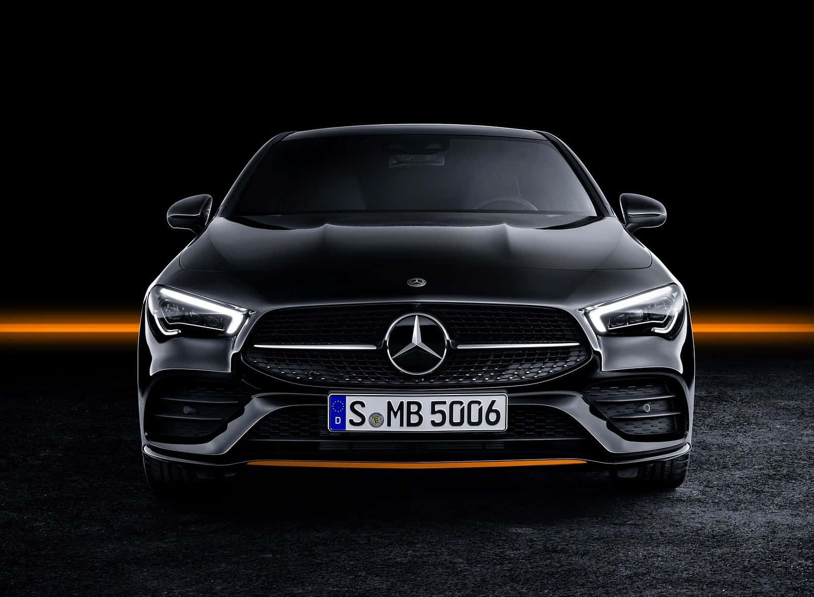 黑色 Mercedes-AMG CLA 跑車在黑暗的攝影棚中帶有橙色重點照明。