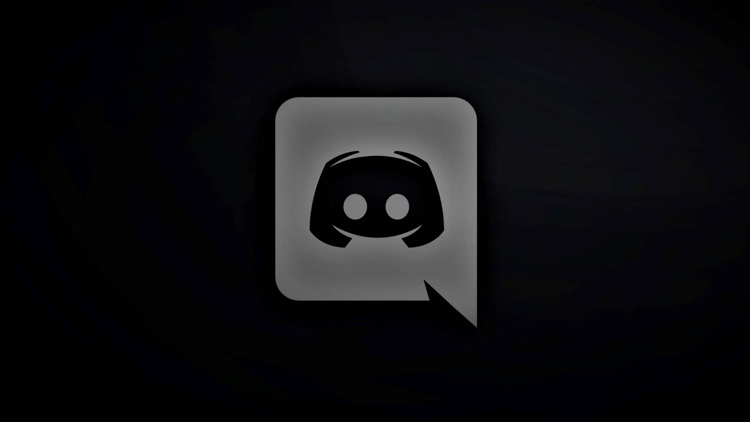黑色極簡風格 Discord 標誌 壁紙 — 一個發光的Discord標誌圖示，置中於帶有柔和光線漸變的深色紋理背景上。