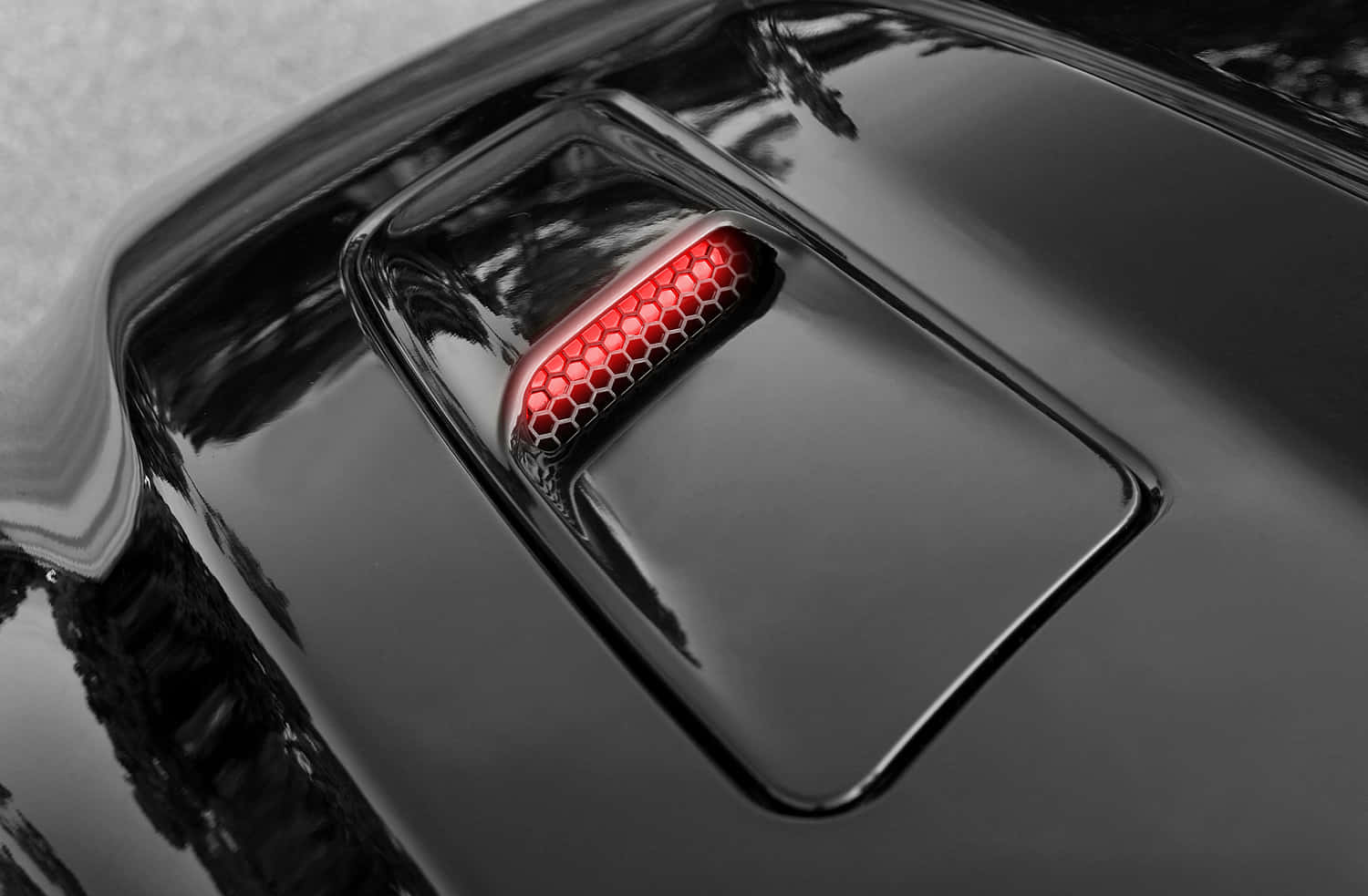 Car Hood 桌布 壁紙 — 黑色流線型汽車的引擎蓋進氣口特寫，散發著鮮豔的紅色六角形LED燈光。