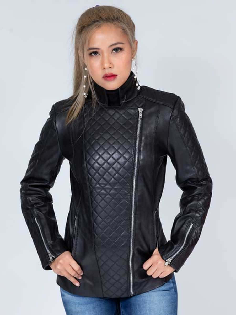 女性穿著黑色絎縫皮革外套和藍色牛仔褲的攝影棚肖像。