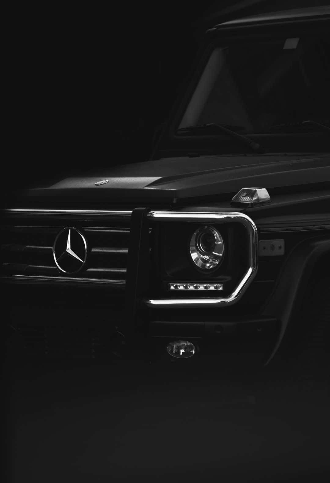 工作室燈光下黑色梅賽德斯 G-Wagen 前格柵和頭燈的特寫。