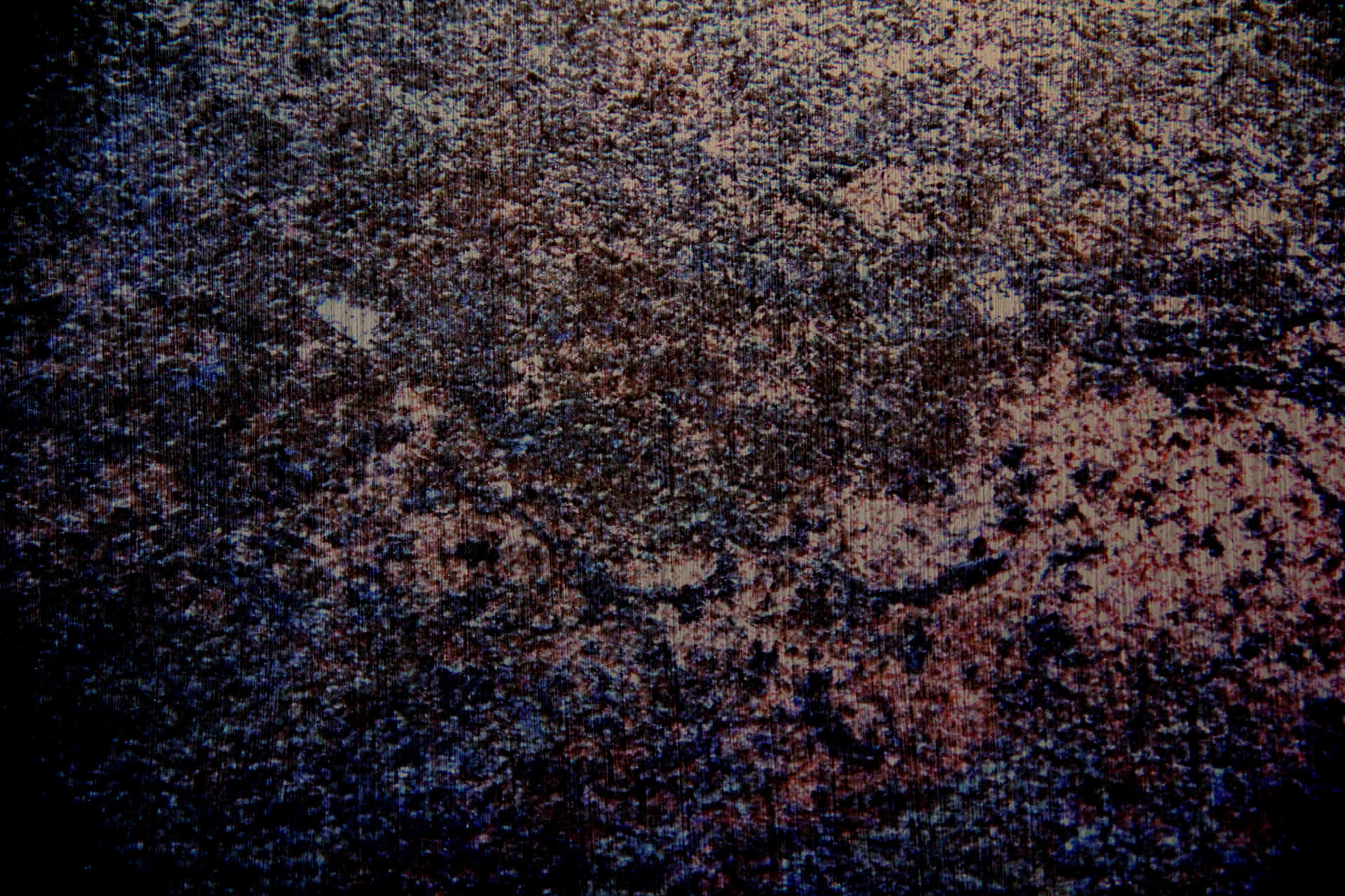 粗糙紋理表面的特寫，帶有深藍色和鏽褐色色調。