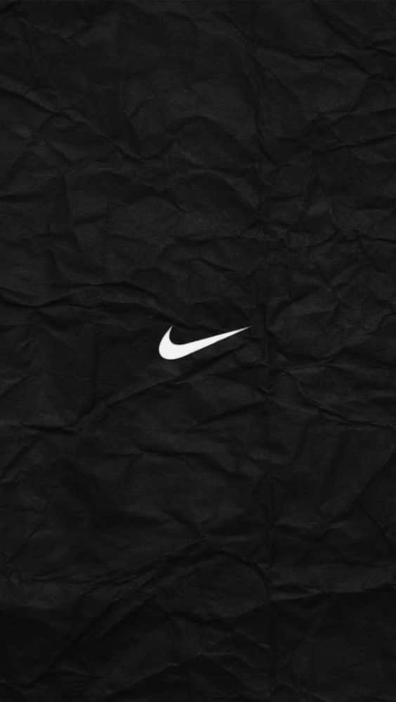 白色Nike標誌在黑色皺紙背景上。