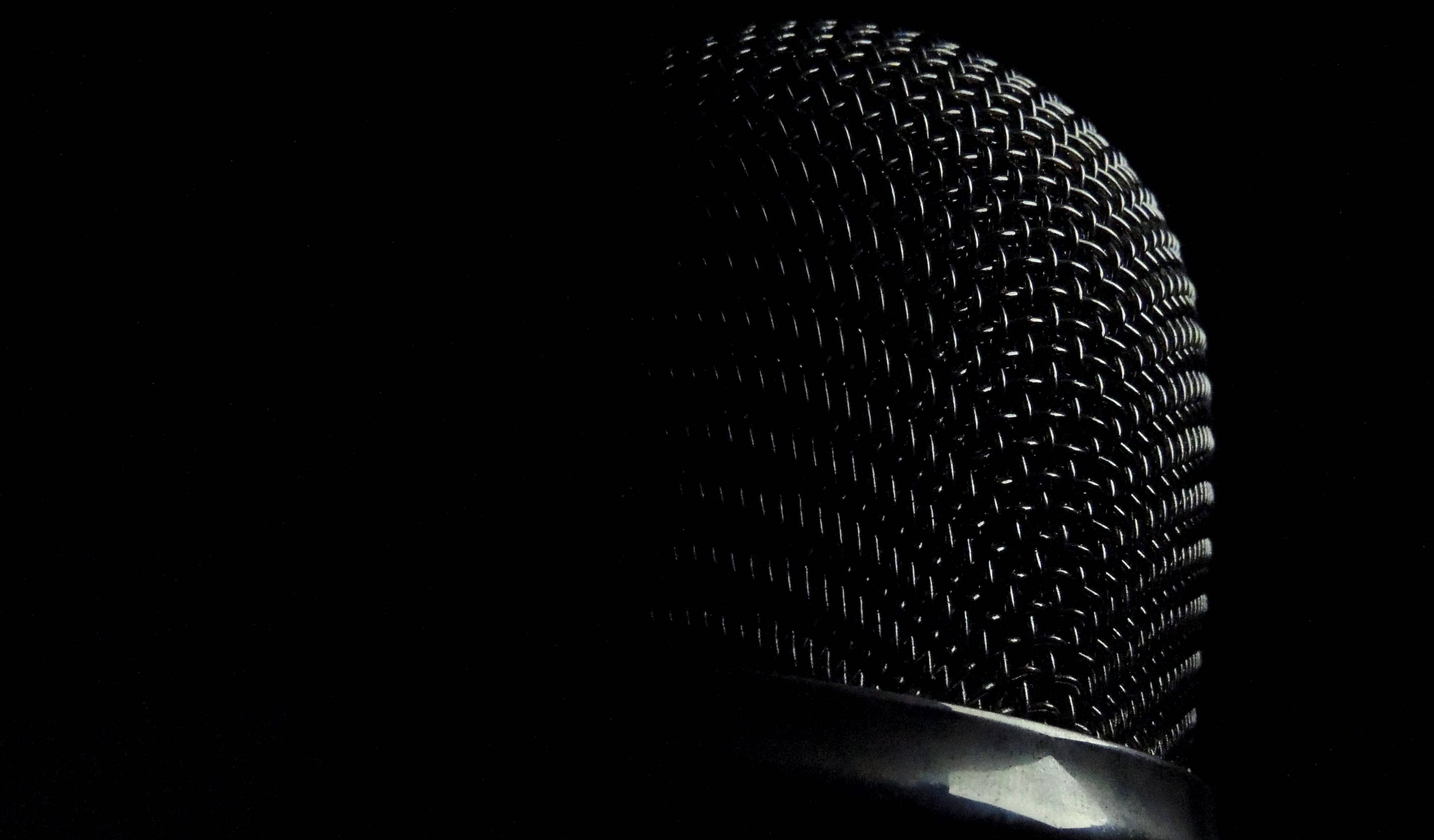 Microphone 桌布 壁紙 — 黑色背景上單一燈光照亮的咪高峰格柵特寫。