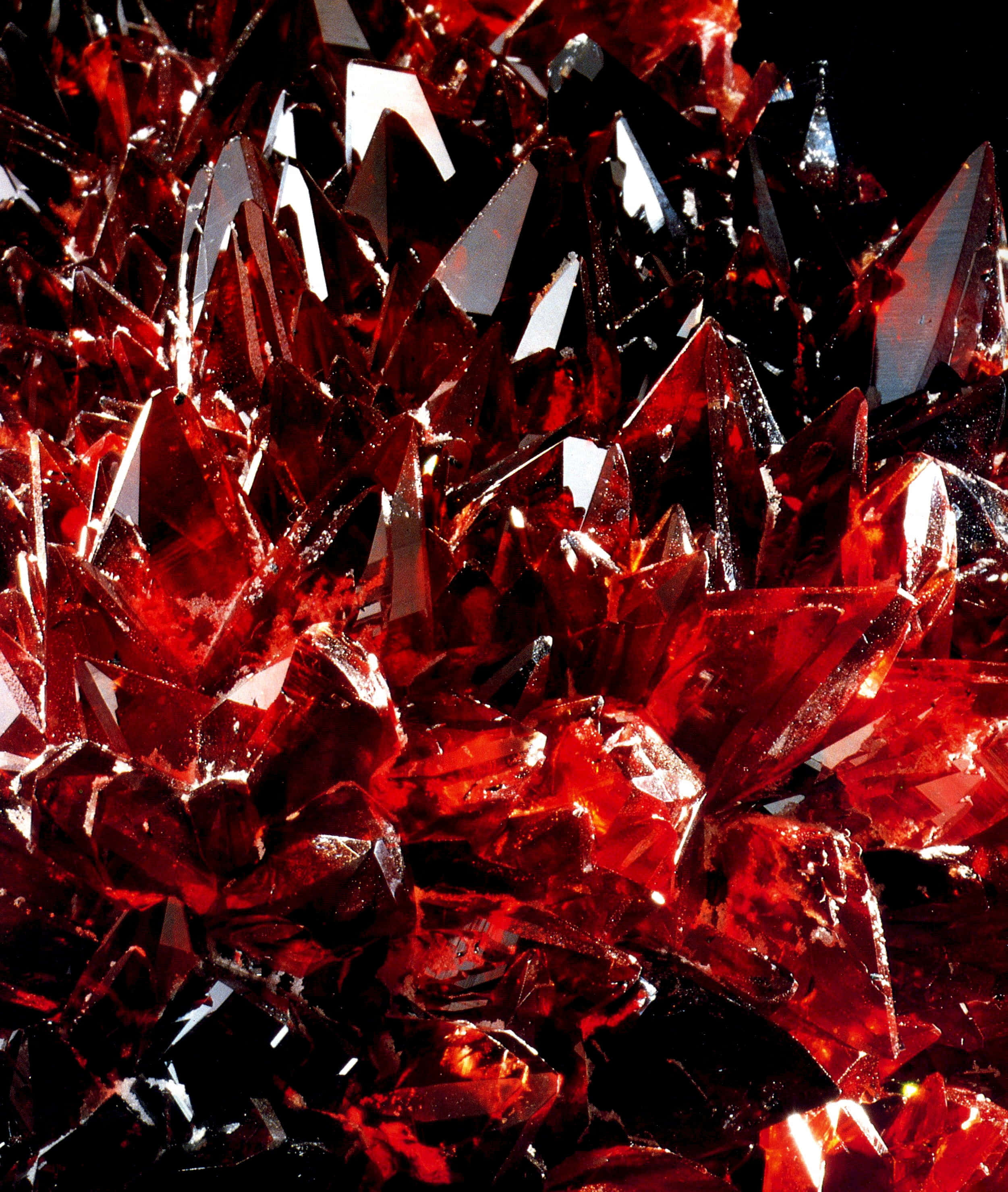Gemstone 桌布 壁紙 — 黑色背景上捕捉光線的鮮紅色晶體結構特寫，帶有鋒利刻面。